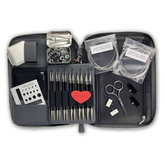 ChiaoGoo FORTÉ 2.0 Complete Set fully open: blackwood and carbon fiber interchangeable tips in labeled pockets, packaged cables, embroidery scissors, stitch markers, T-pins, end stoppers, and a red ChiaoGoo heart gripper