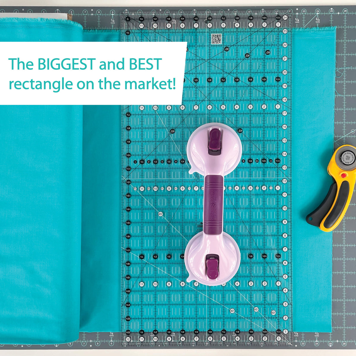 Creative Grids 12-1/2 x 24-1/2 inch Big Easy ruler CGR1224 on teal fabric with a suction-cup ruler handle and a rotary cutter, with a brand caption calling it the biggest rectangle on the market.