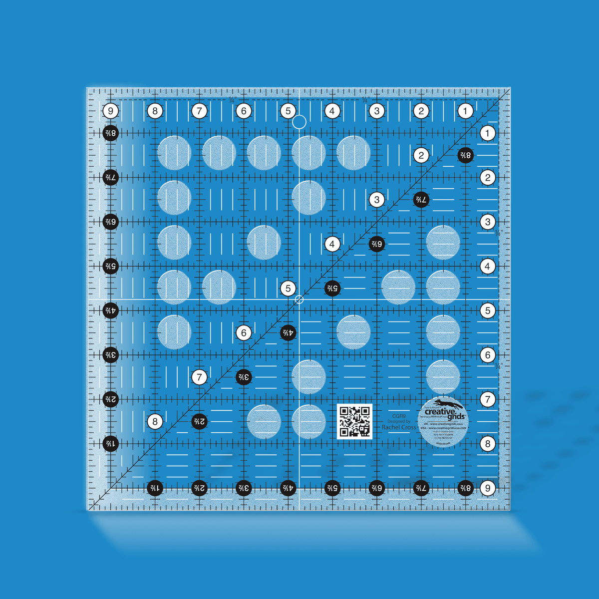 Creative Grids 9-1/2 inch square quilt ruler CGR9 by Rachel Cross rendered in translucent blue acrylic with black and white grid markings, whole-inch numbers in white dots, half-inch Turn-a-Round numbers in black dots, a 45 degree diagonal, a 1/4 inch dashed seam line, and white centering lines.