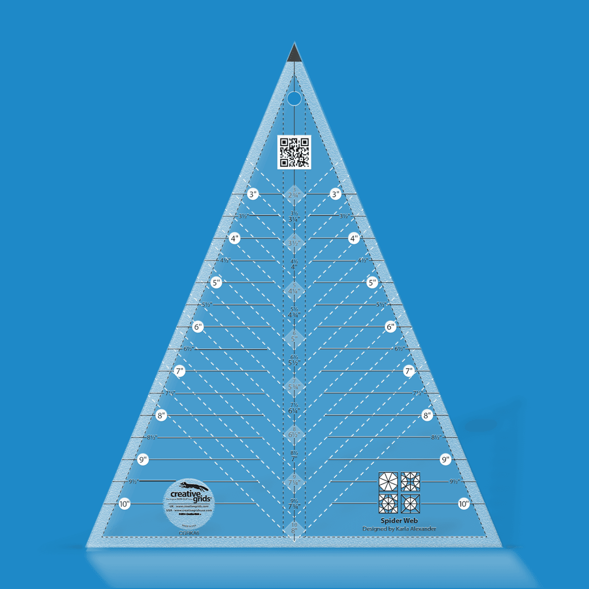 Creative Grids Spider Web Ruler CGRKA6 by Karla Alexander in translucent blue acrylic, a triangle with a black tip, horizontal lines labeled 3 to 10 inches on both sides, a center column of paired measurements, white dashed diagonal lines, a QR code, and four block icons above the Designed by Karla Alexander credit.