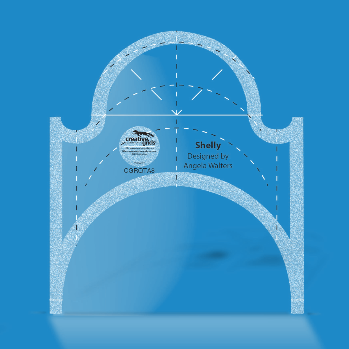 Creative Grids Shelly Machine Quilting Ruler CGRQTA8 by Angela Walters in translucent blue acrylic with a half-circle dome on top, a large arch cut from the bottom, black and white dashed arcs, a dashed center line, and the name Shelly above the Designed by Angela Walters credit.