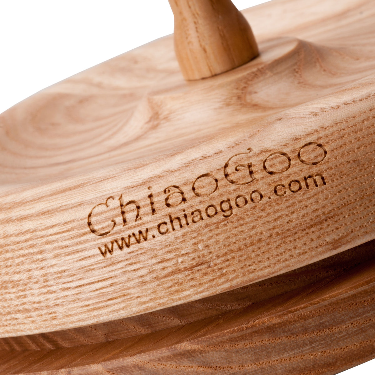 Close-up of the base of a ChiaoGoo wood Yarn Butler. The top layer carries the engraved ChiaoGoo name and www.chiaogoo.com, and a gap separates it from the darker bottom layer.