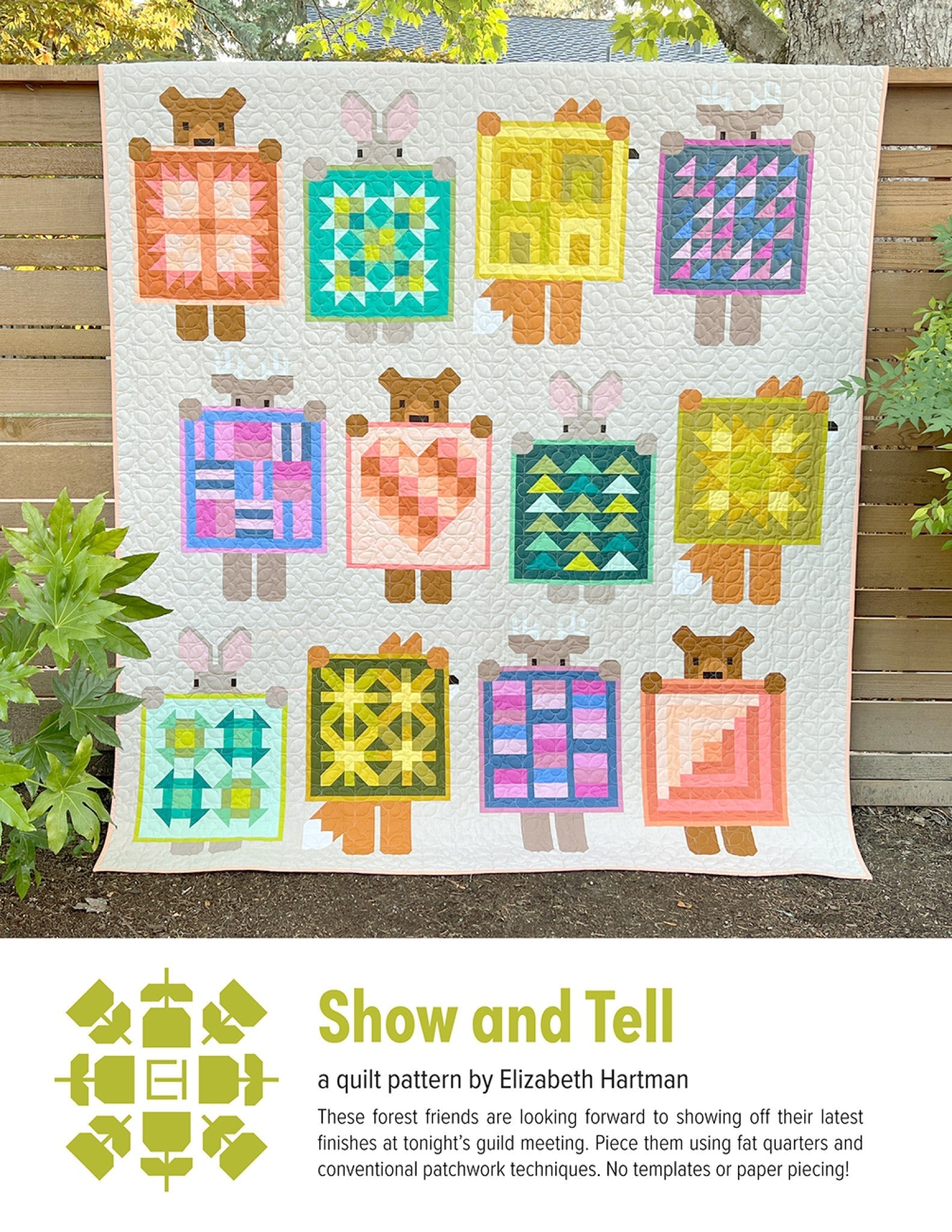 Show and Tell quilt pattern cover by Elizabeth Hartman. Large quilt displayed outdoors on a wooden fence shows 12 blocks in a 4 by 3 grid, each featuring a patchwork animal -- fox, bunny, deer, or bear -- holding a different mini quilt design in coordinated solid fabrics on a white background.