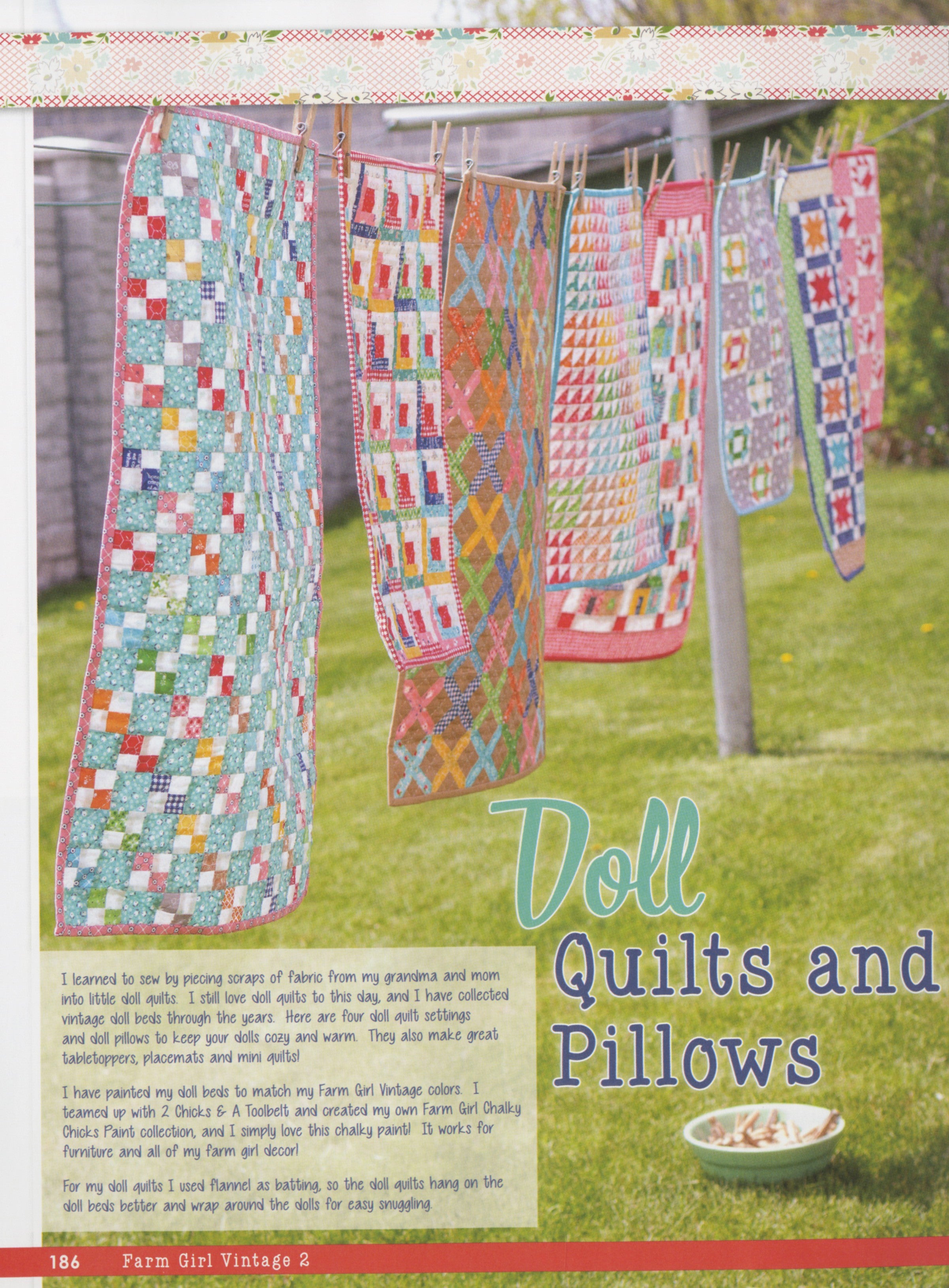 Several doll-size scrappy patchwork quilts from Farm Girl Vintage 2 by Lori Holt for It's Sew Emma hanging on a clothesline in a grassy yard, on the Doll Quilts and Pillows page.
