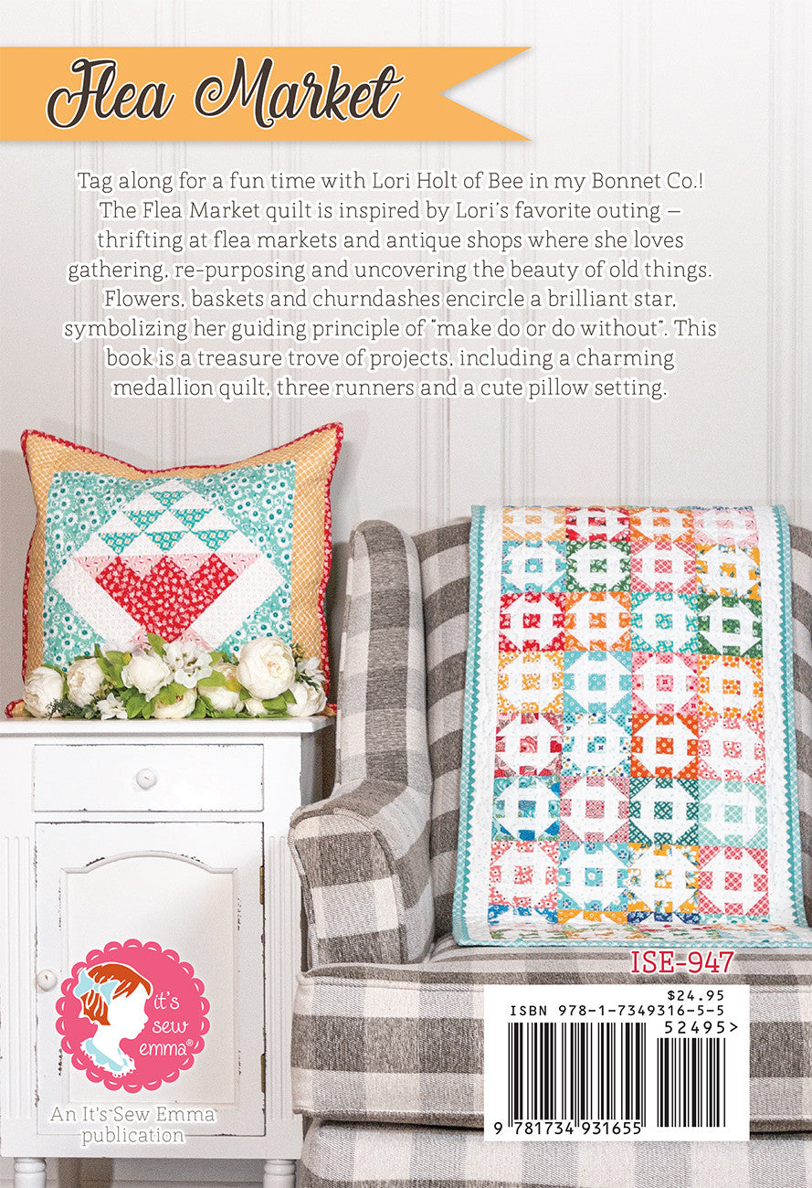 Back cover of Flea Market by Lori Holt for It's Sew Emma. A basket-block pillow on a white dresser with white flowers, and a churn dash table runner on a gray gingham chair, with the It's Sew Emma logo and item number ISE-947.