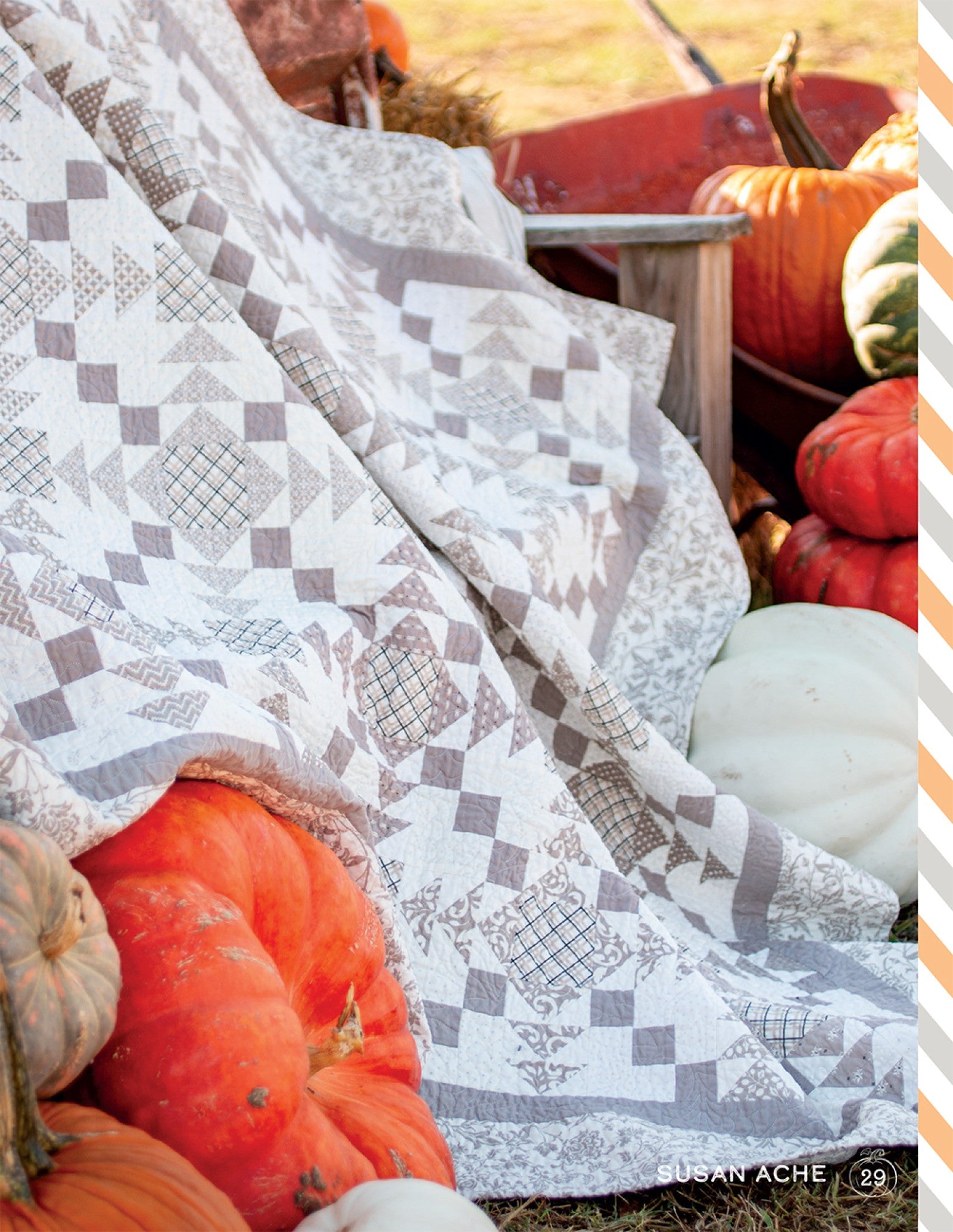 A soft grey and orange pieced Halloween quilt from Halloween Memories, styled with pumpkins.