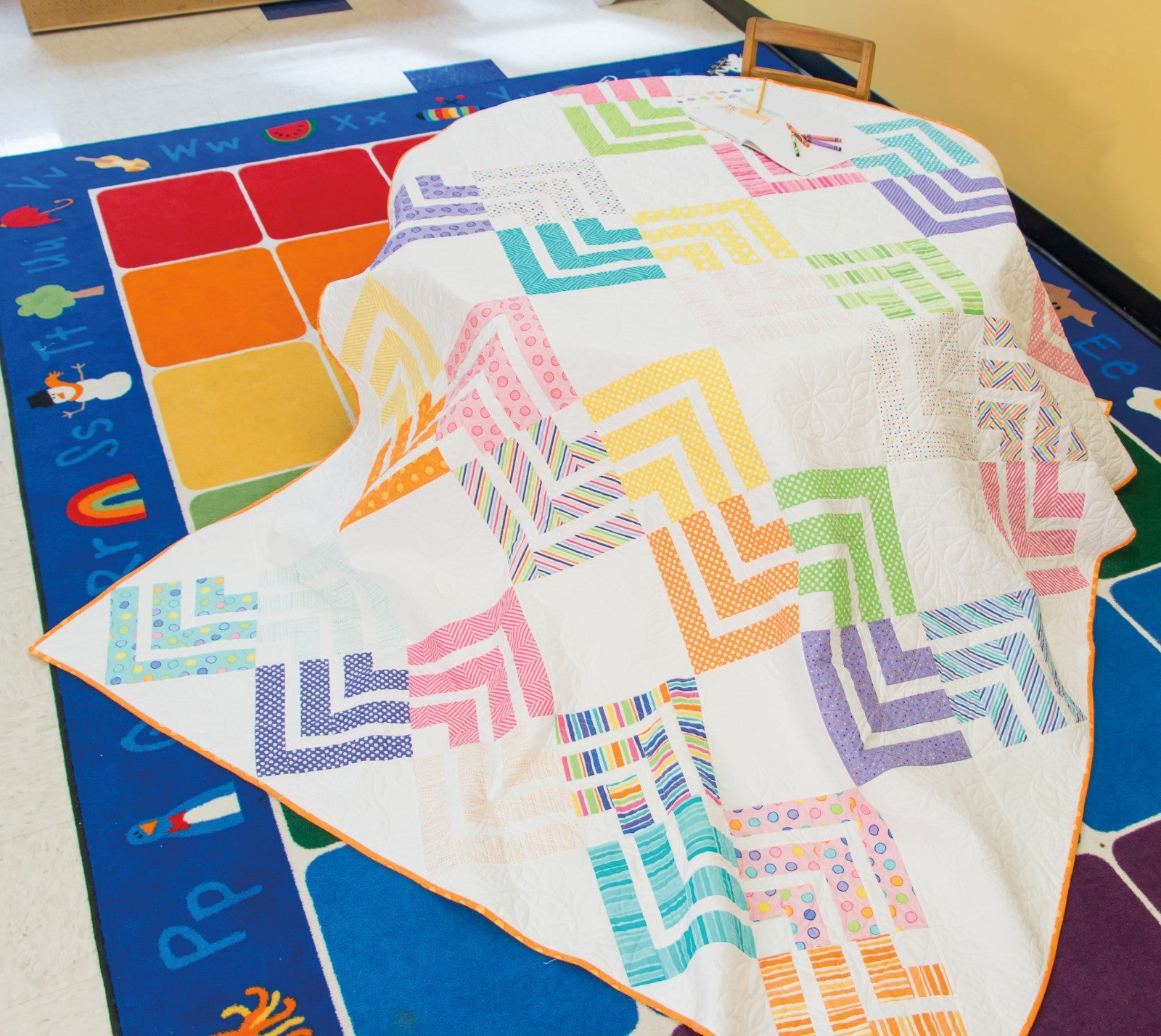 Interior quilt from Precut Primer, pastel chevron design on a white background.