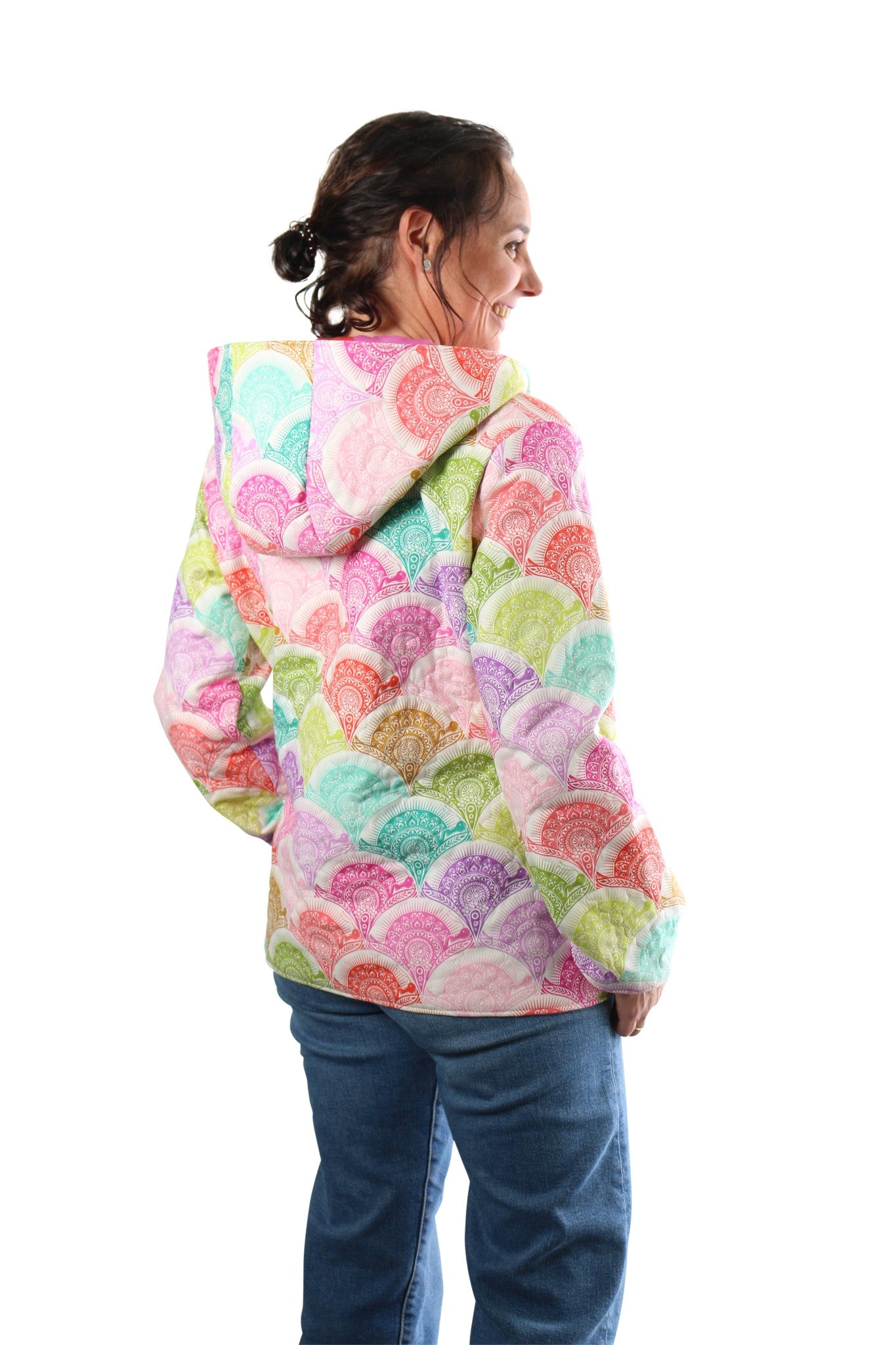 Side-back view of a person wearing a pastel scallop-print Bella Quilt Coat with the hood down.