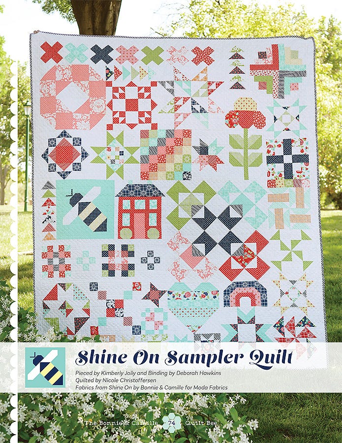 Shine On Sampler Quilt from The Bonnie & Camille Quilt Bee, the centerpiece sampler of many pieced blocks in red, aqua, navy, and cream.