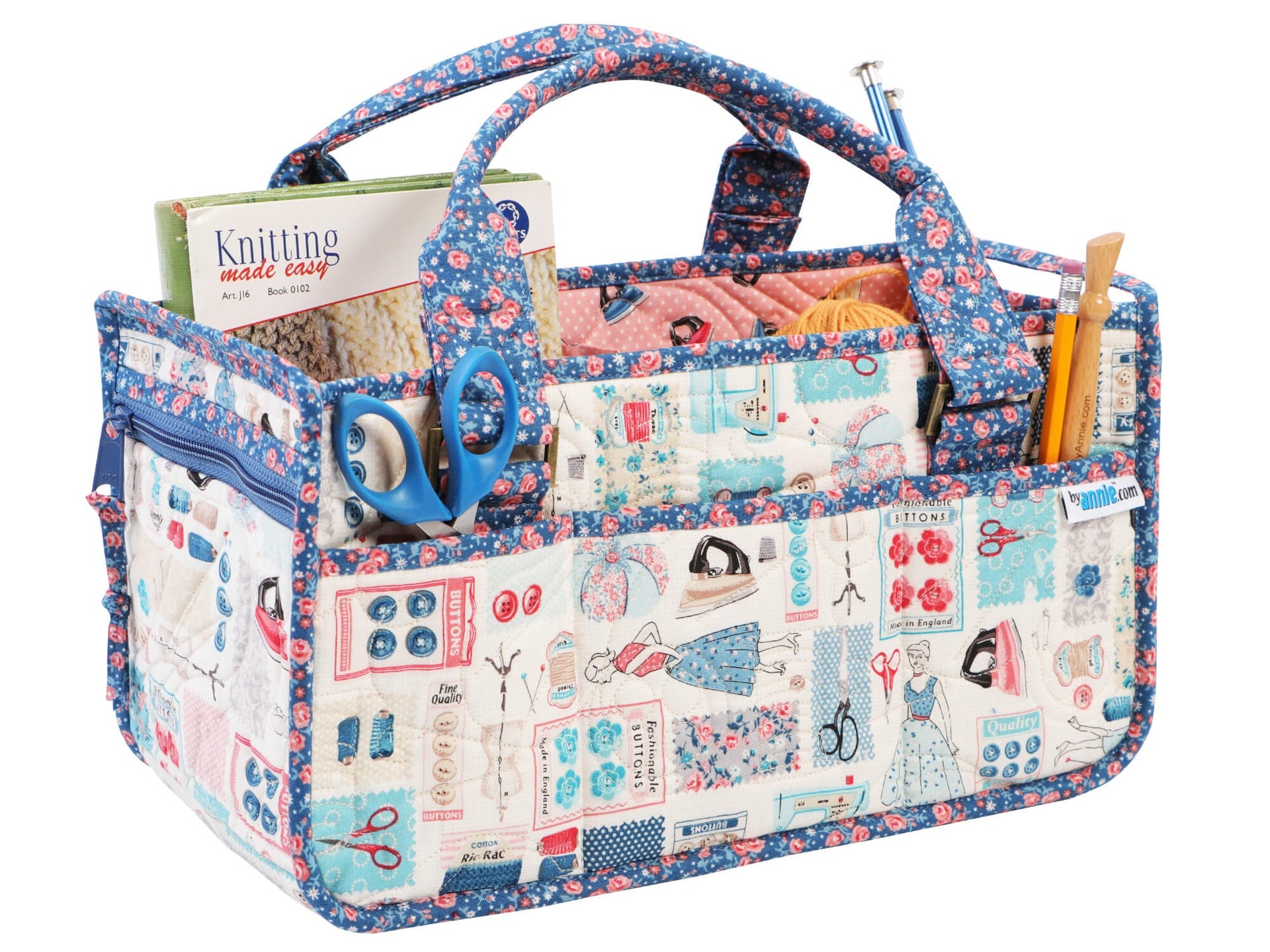Catch All Caddy 2.0 sewn in a vintage sewing-notions print, holding a knitting magazine, scissors, and needles as a portable sewing and knitting organizer.