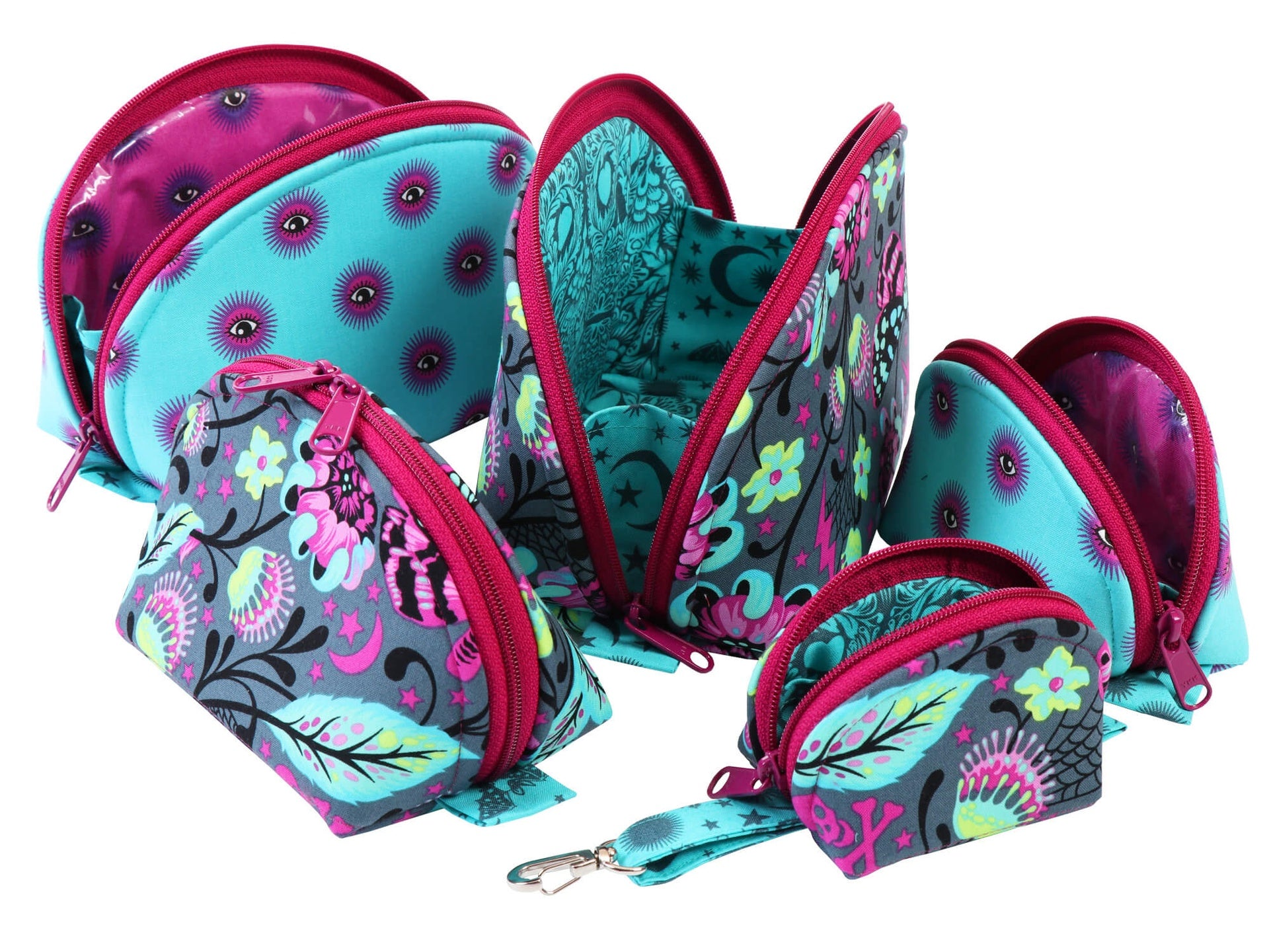 A set of Clam Up pouches with one open wide, showing the clamshell opening and attached side panels.