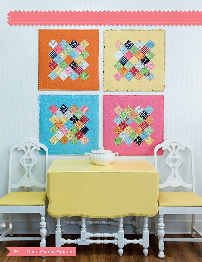 Interior page from the Great Granny Squared quilt pattern book by Lori Holt for It's Sew Emma, showing four small granny-square mini quilts in orange, pale yellow, blue, and pink on a white wall above a yellow drop-leaf table set between two white chairs.