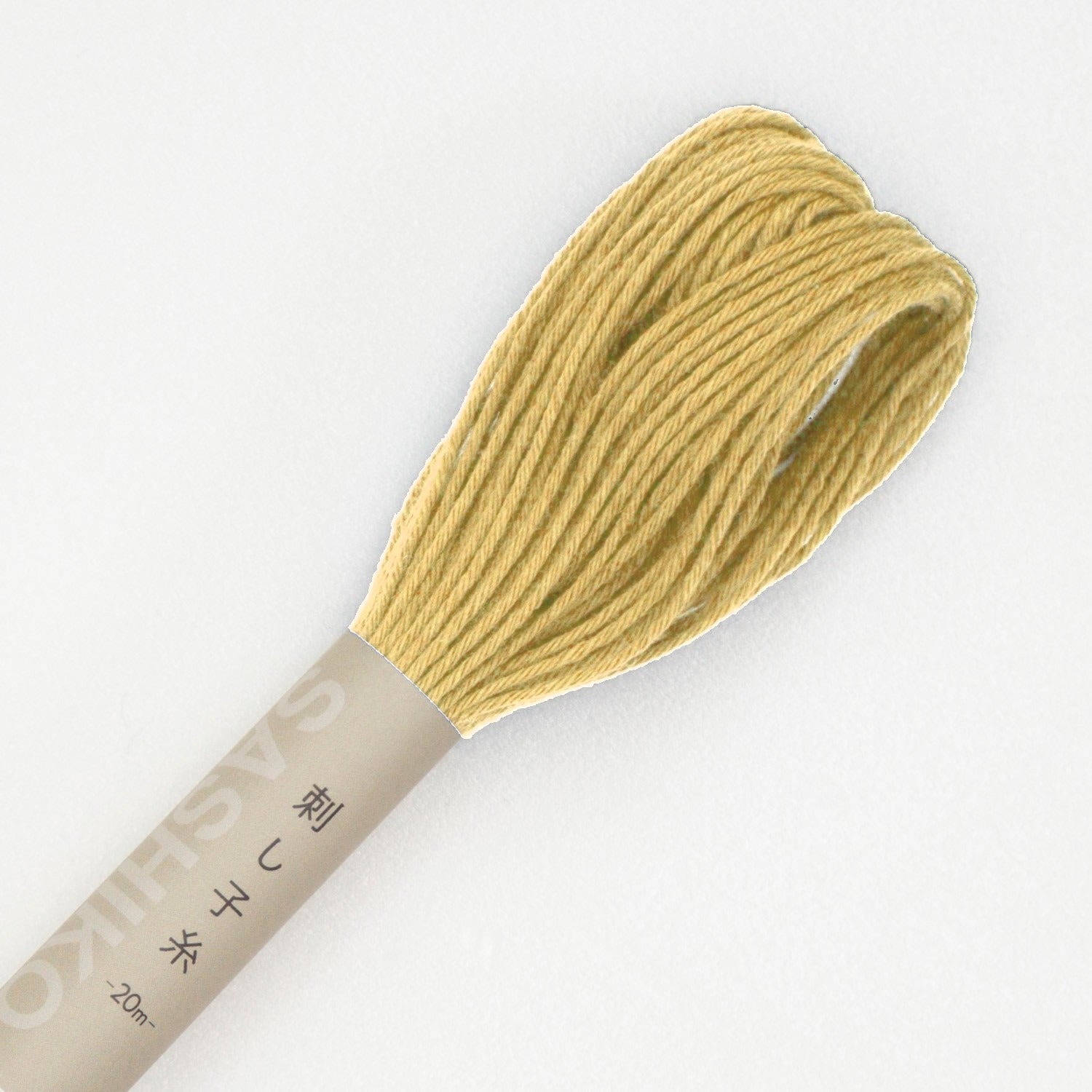 Olympus sashiko thread in gold, a close view of the looped end of a warm mustard-gold cotton skein above its kraft SASHIKO paper band, on a white background.