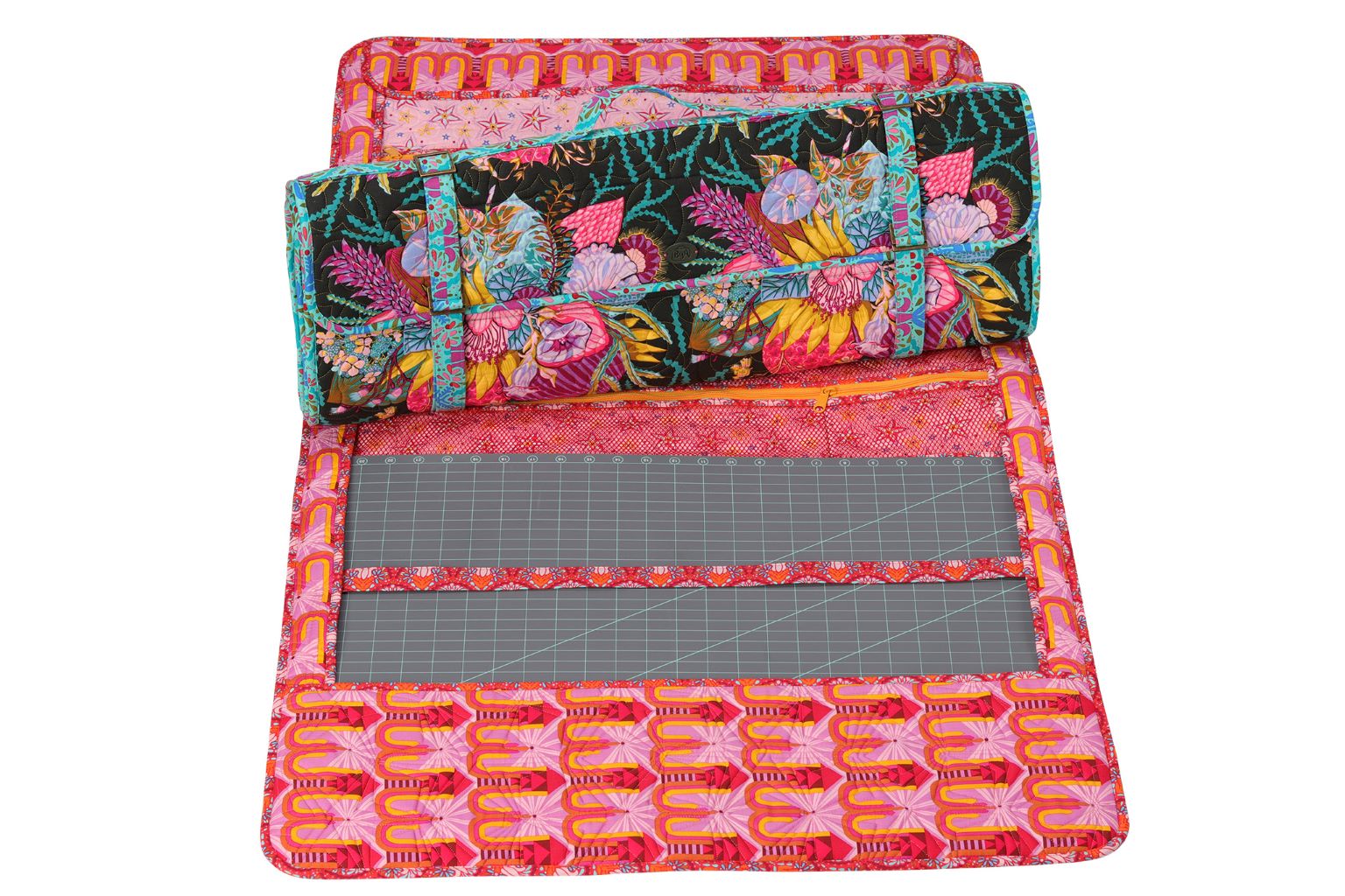 A Ruler Wrap opened flat to show a cutting mat and quilted pockets holding quilting rulers.