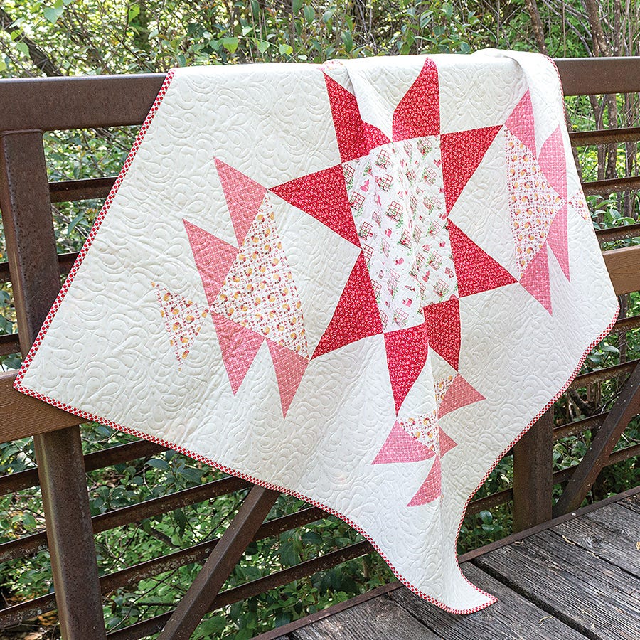 Peaceful Quilt from Simply Half Yards, a large pink and red star on a white background.