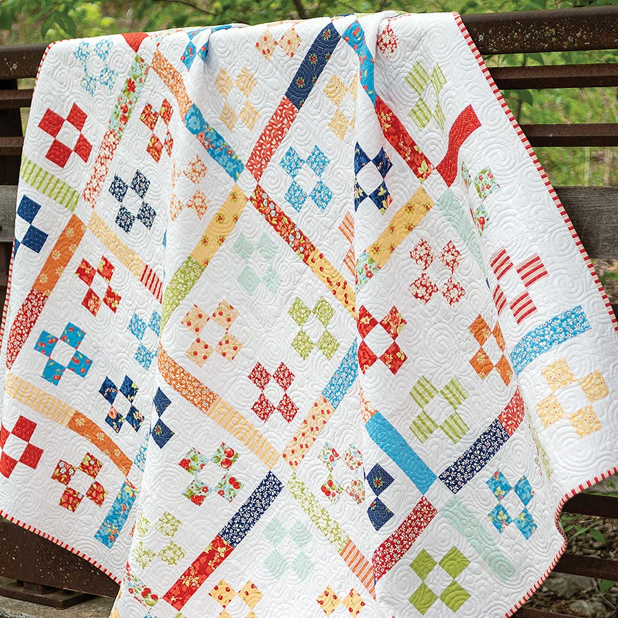 Ciabatta Quilt from Simply Jelly Rolls, a nine-patch and strip design in bright prints on white.