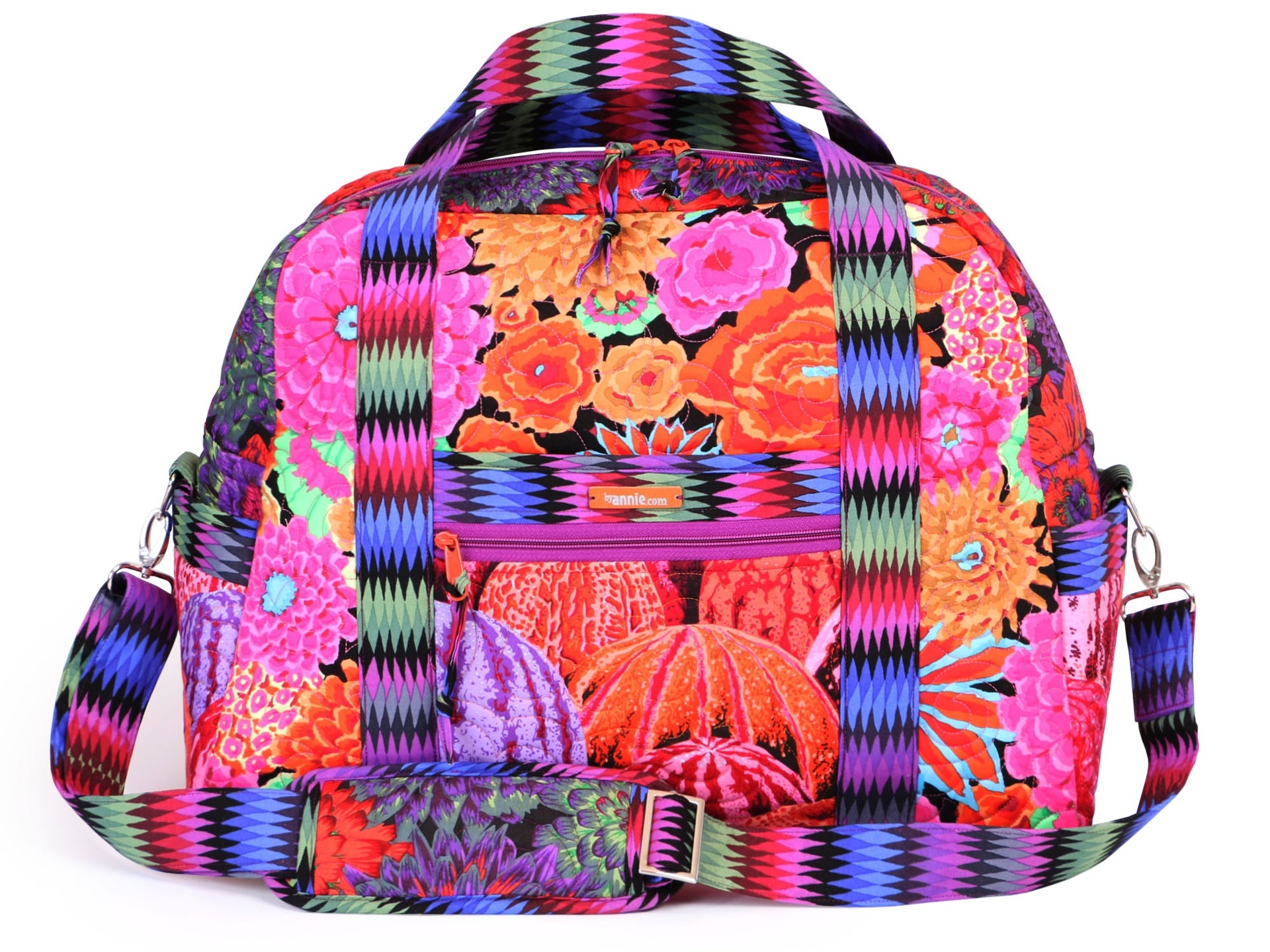 A finished Ultimate Travel Bag in a bright print shown from the front with side handles, an adjustable strap, and front zippered pockets.