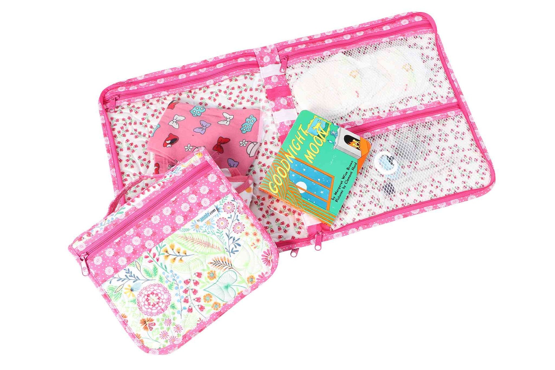 A pink Zip It Up organizer opened flat, showing the clear vinyl zippered pockets and their contents.