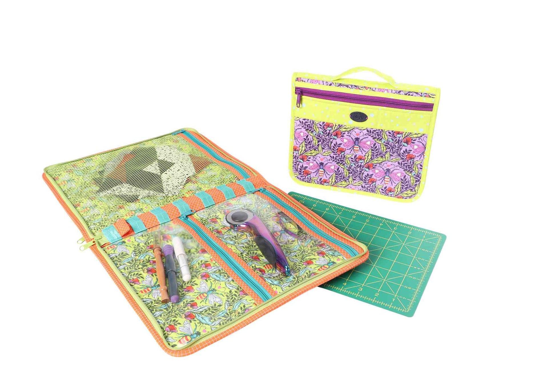 A Zip It Up organizer opened flat on a cutting mat beside the smaller case, holding rotary tools and notions.