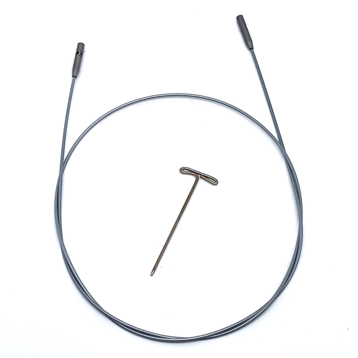 ChiaoGoo SWIV360 silver interchangeable knitting needle cable out of its package on a white background. The silver-gray nylon-coated cable lies in a loop with a gray metal join at each end, and a small hole shows in one join. A T-shaped metal tightening key lies in the center of the loop.
