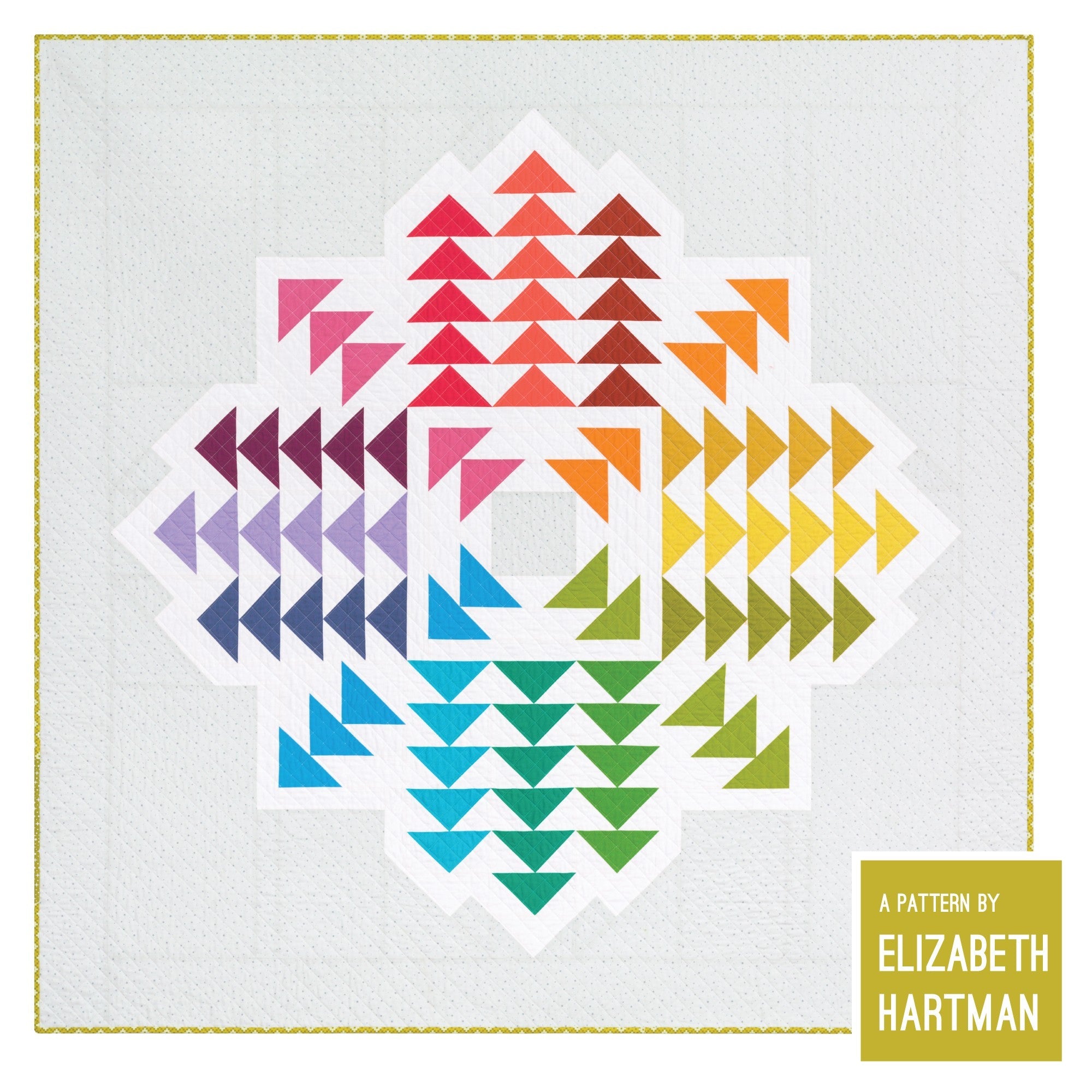 Crystal Cluster 70 by 70 inch lap quilt by Elizabeth Hartman shown flat from the front. The full symmetrical starburst design is visible -- flying geese units in a full rainbow gradient of 16 Kona Solids arranged in a large crystal shape with four diagonal arms radiating from a central square on a white background with yellow-green binding.