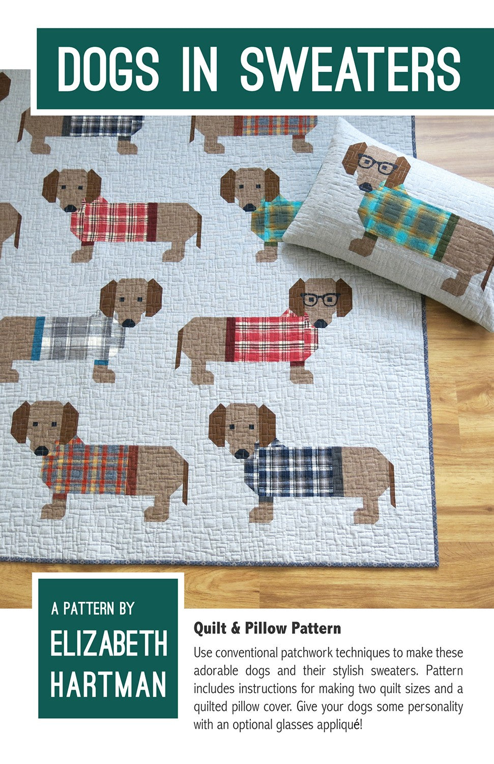 Dogs in Sweaters quilt pattern cover by Elizabeth Hartman. Quilt and lumbar pillow displayed on a wood floor show patchwork dachshunds in warm brown tones wearing plaid and gingham sweaters in red, teal, gray, and navy on a charcoal linen-textured background. One dog on the pillow wears optional patchwork glasses.