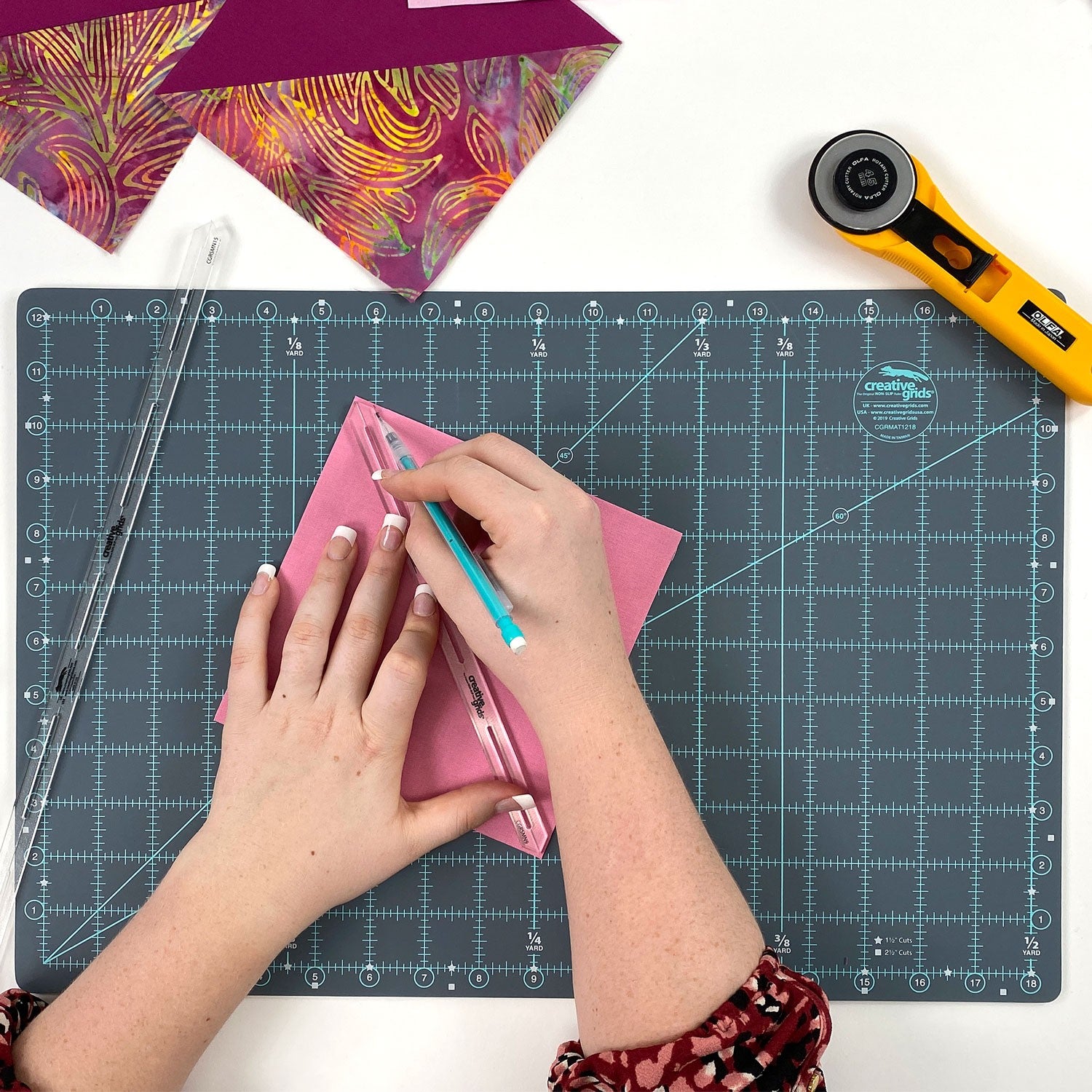 Marking seam lines on fabric square with a Creative Grids 9-inch Seam Guide and Marking Quilt Tool