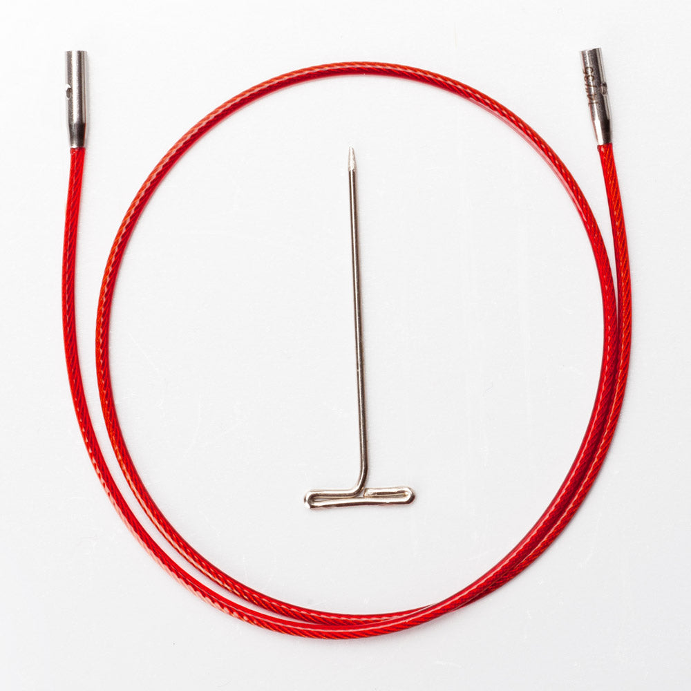 ChiaoGoo TWIST red interchangeable knitting needle cable out of its package on a white background. The red nylon-coated cable lies in a loop with a silver metal join at each end, and a small hole shows in one join. A T-shaped metal tightening key lies in the center of the loop.