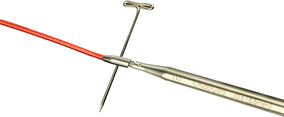 A ChiaoGoo TWIST Lace stainless steel tip joined to a red TWIST cable on a gray background. A T-shaped tightening key passes through the hole in the cable's metal join. Laser markings on the tip read [L], ChiaoGoo, and 10.5 (6.5 mm).