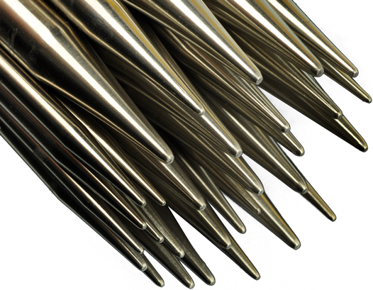 Close-up of the points of ChiaoGoo TWIST Lace stainless steel interchangeable knitting needle tips: a bundle of polished steel tips in several sizes on a gray background, each tapering to a sharp lace point.