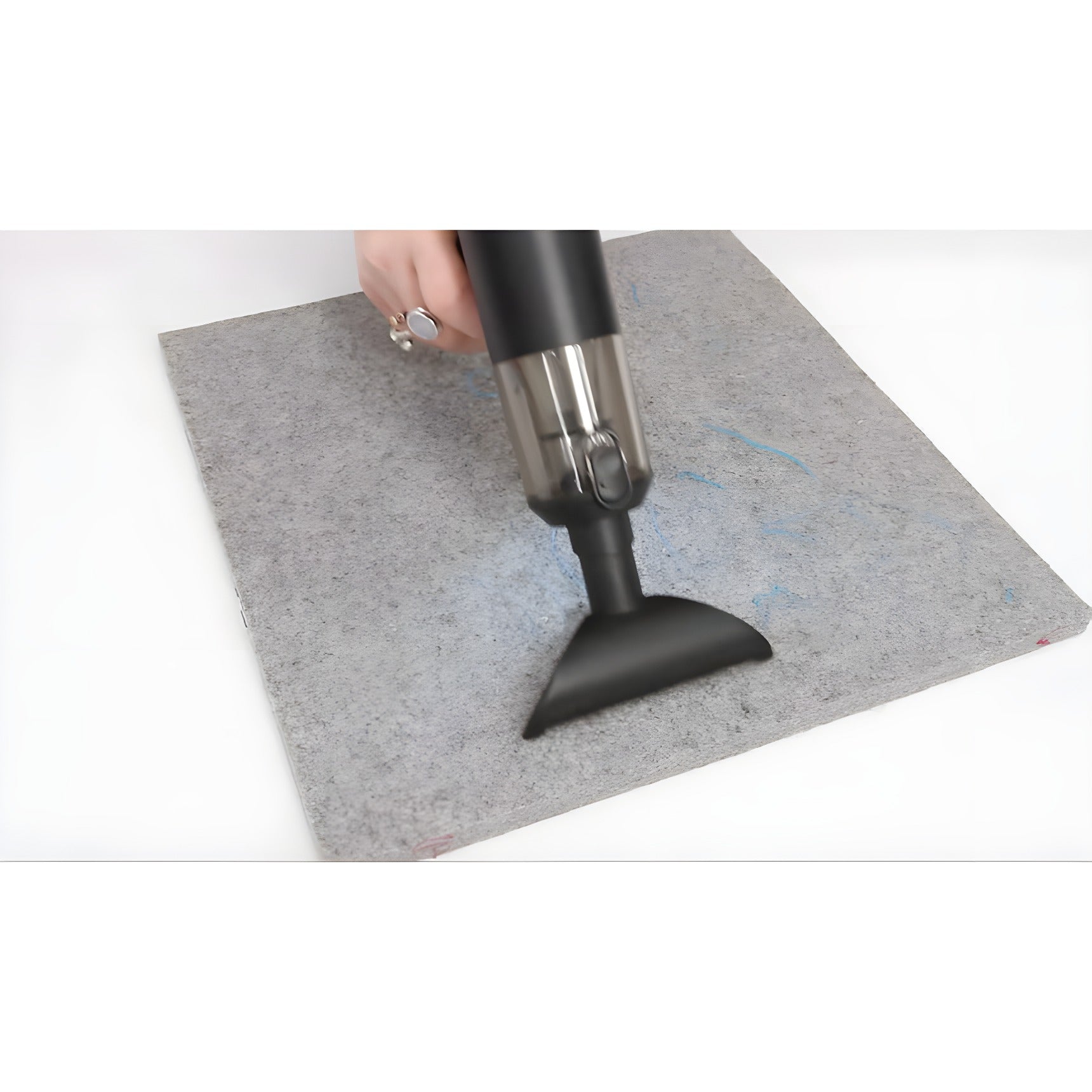 A person using the SewClean vacuum with the wide flared nozzle to clear thread ends from a gray wool pressing mat.