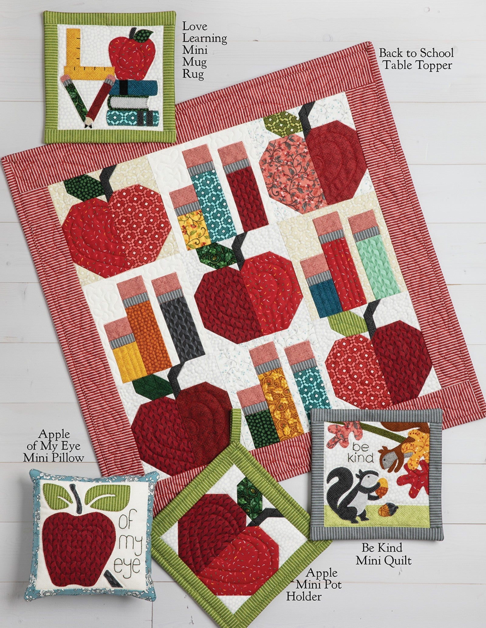 Interior page of the Schoolhouse Haven on Wander Lane pattern showing bonus projects such as a table topper, mini quilts, pot holder, pillows, and a mug rug.