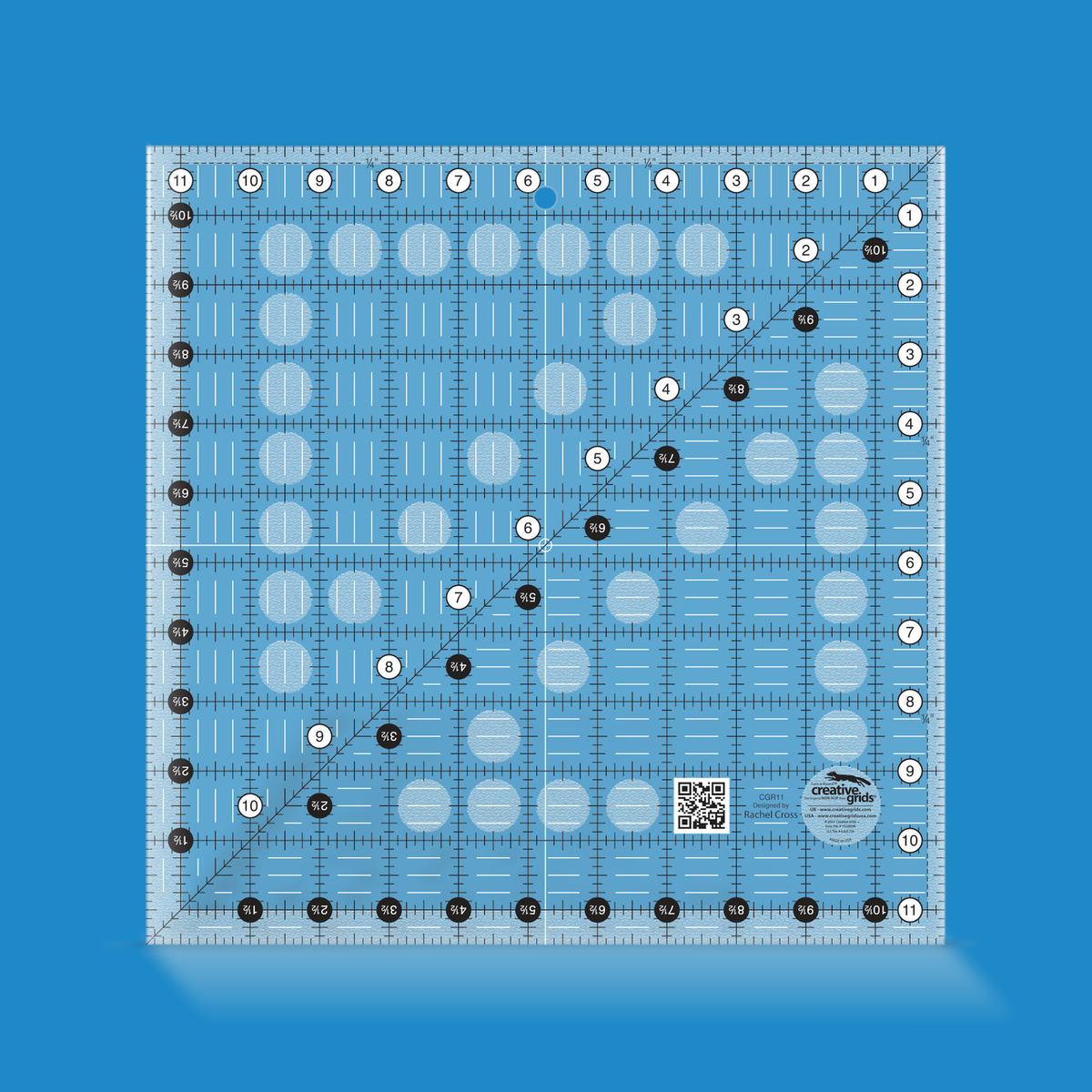 Creative Grids 11-1/2 inch square quilt ruler CGR11 by Rachel Cross rendered in translucent blue acrylic with black and white grid markings, whole-inch numbers in white dots, half-inch Turn-a-Round numbers in black dots, a 45 degree diagonal, a 1/4 inch dashed seam line, and white centering lines.