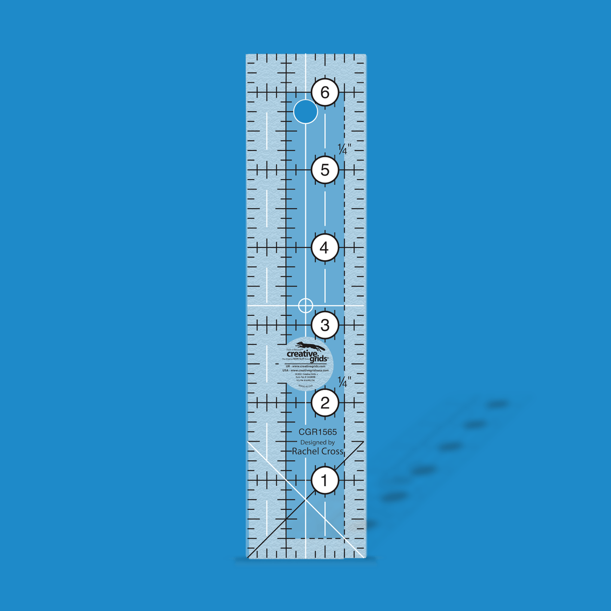 Creative Grids 1-1/2 x 6-1/2 inch rectangle quilt ruler CGR1565 by Rachel Cross rendered in translucent blue acrylic with black and white grid markings, whole-inch numbers in white dots along the length, crossed black and white 45 degree lines at one end, and a 1/4 inch dashed seam line.