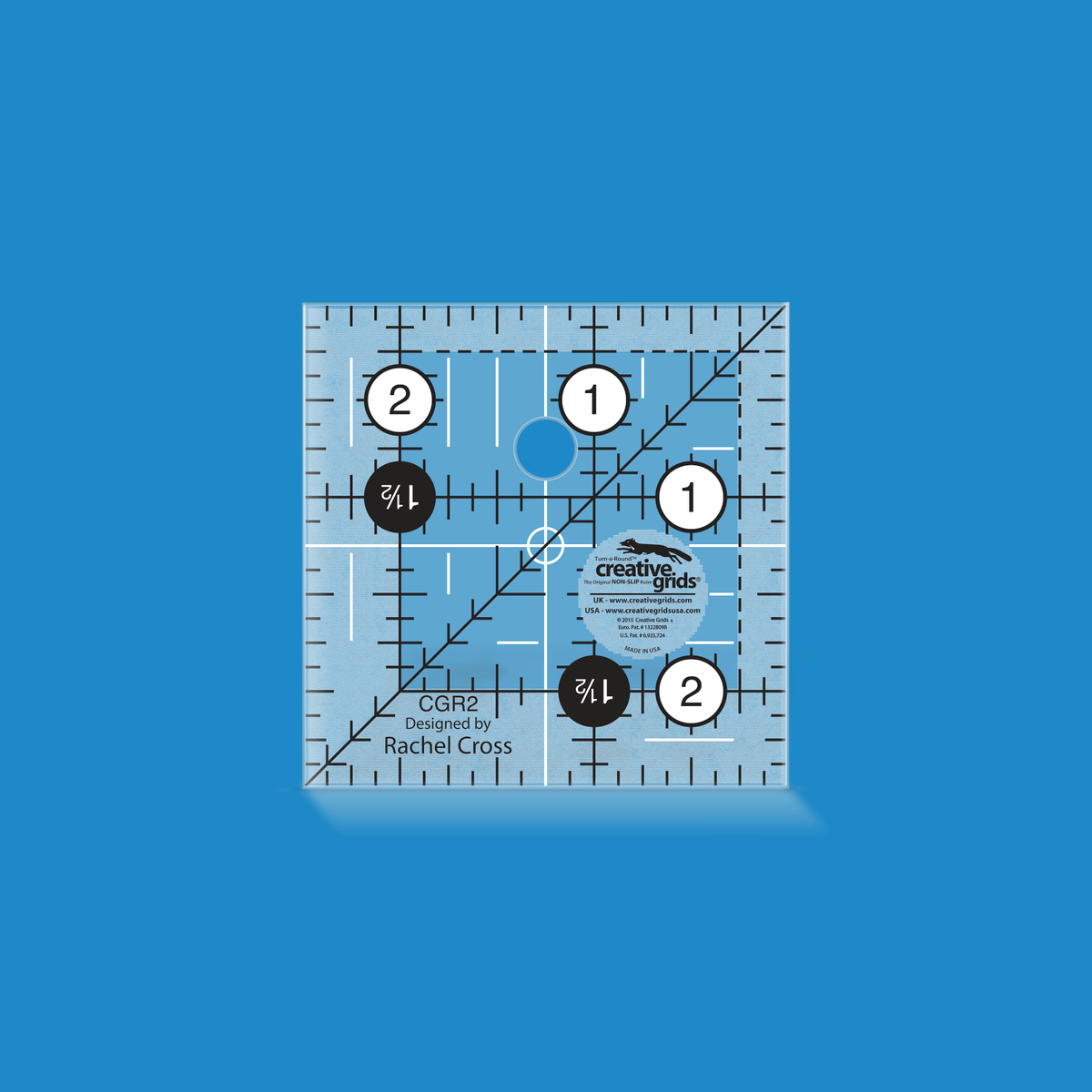 Creative Grids 2-1/2 inch square quilt ruler CGR2 by Rachel Cross rendered in translucent blue acrylic with black and white grid markings, whole-inch numbers in white dots, a Turn-a-Round number in black dots, a 45 degree diagonal, a 1/4 inch dashed seam line, and white centering lines.