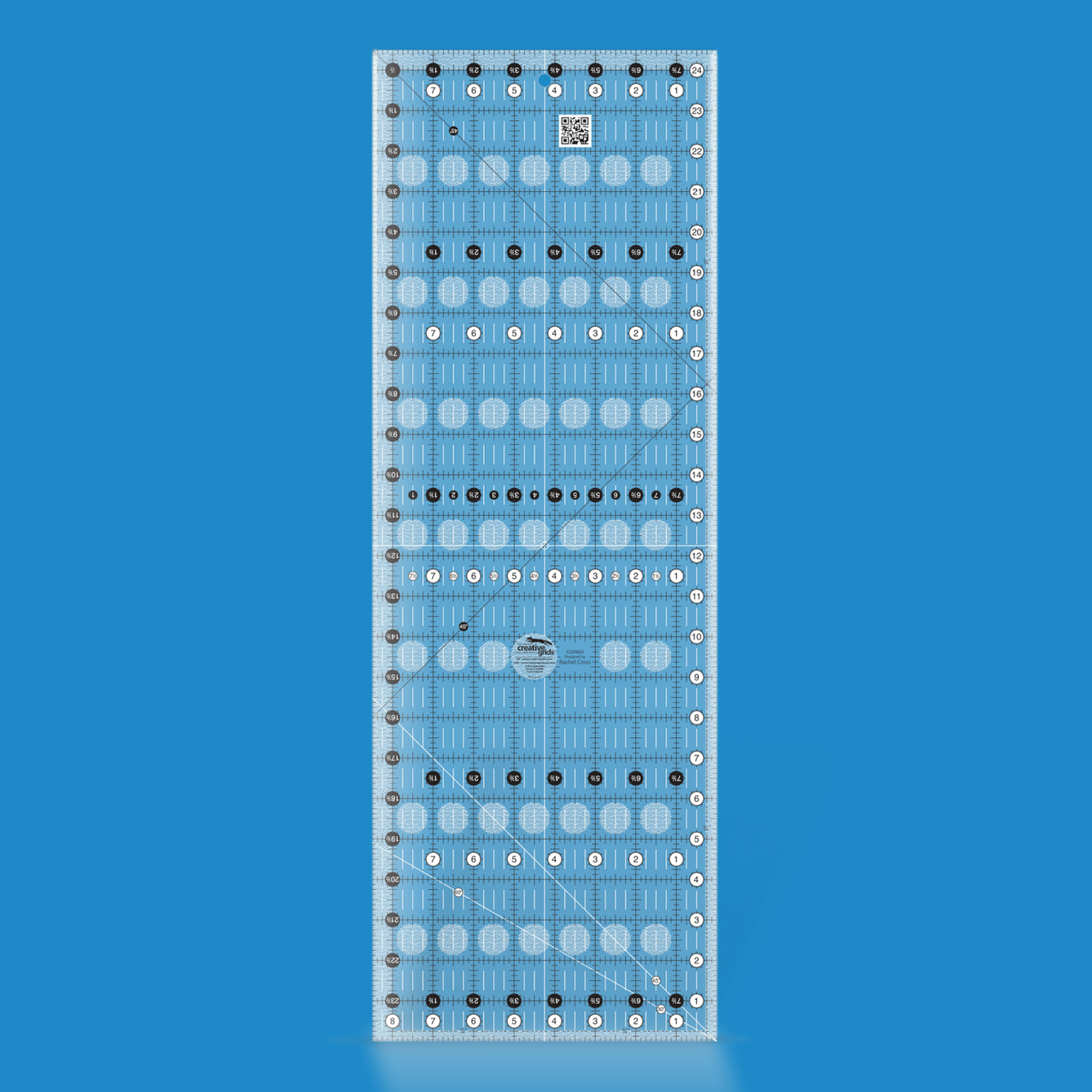 Creative Grids 8-1/2 x 24-1/2 inch rectangle quilt ruler CGR824 by Rachel Cross rendered in translucent blue acrylic with black and white grid markings, whole-inch numbers in white dots, half-inch Turn-a-Round numbers in black dots, crossed 45 degree lines, a 30/60 degree line, a 1/4 inch dashed seam line, and white centering lines.