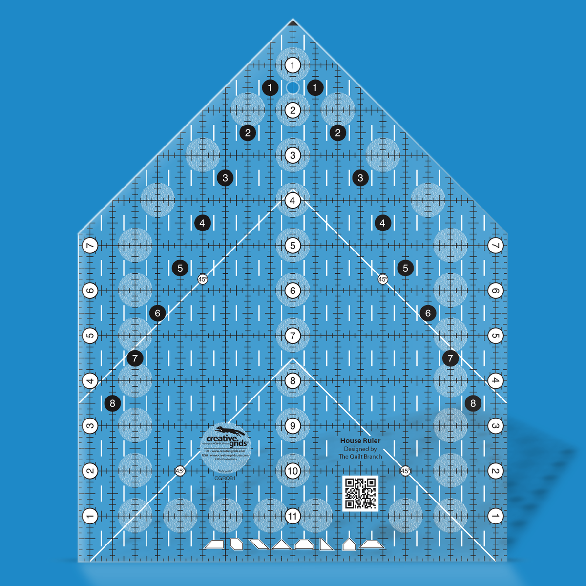 Creative Grids House Ruler CGRQB1 by Susan Knapp in translucent blue acrylic, a house shape with a ticked grid, white numbered circles down the center and sides, black numbered circles along the roof slopes, 45 degree marks, cut-shape icons along the bottom edge, and a QR code.