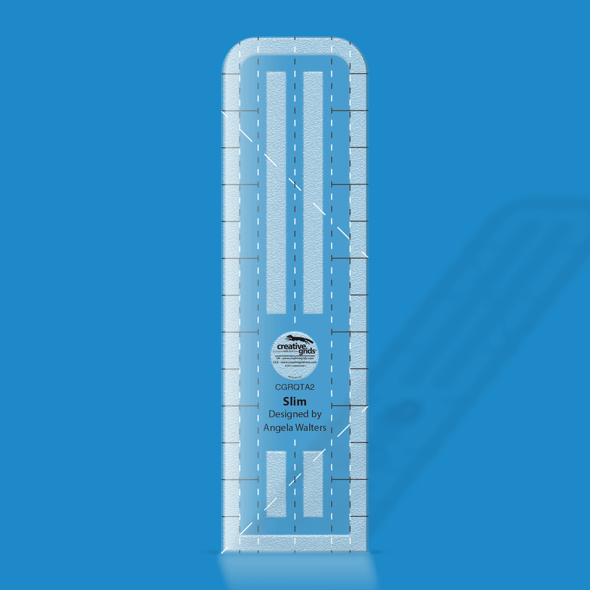 Creative Grids Slim Machine Quilting Ruler CGRQTA2 by Angela Walters in translucent blue acrylic with black and white dashed lengthwise guide lines, solid cross lines along both long sides, white dashed diagonal lines, long grip strips down the middle, and the name Slim above the Designed by Angela Walters credit.