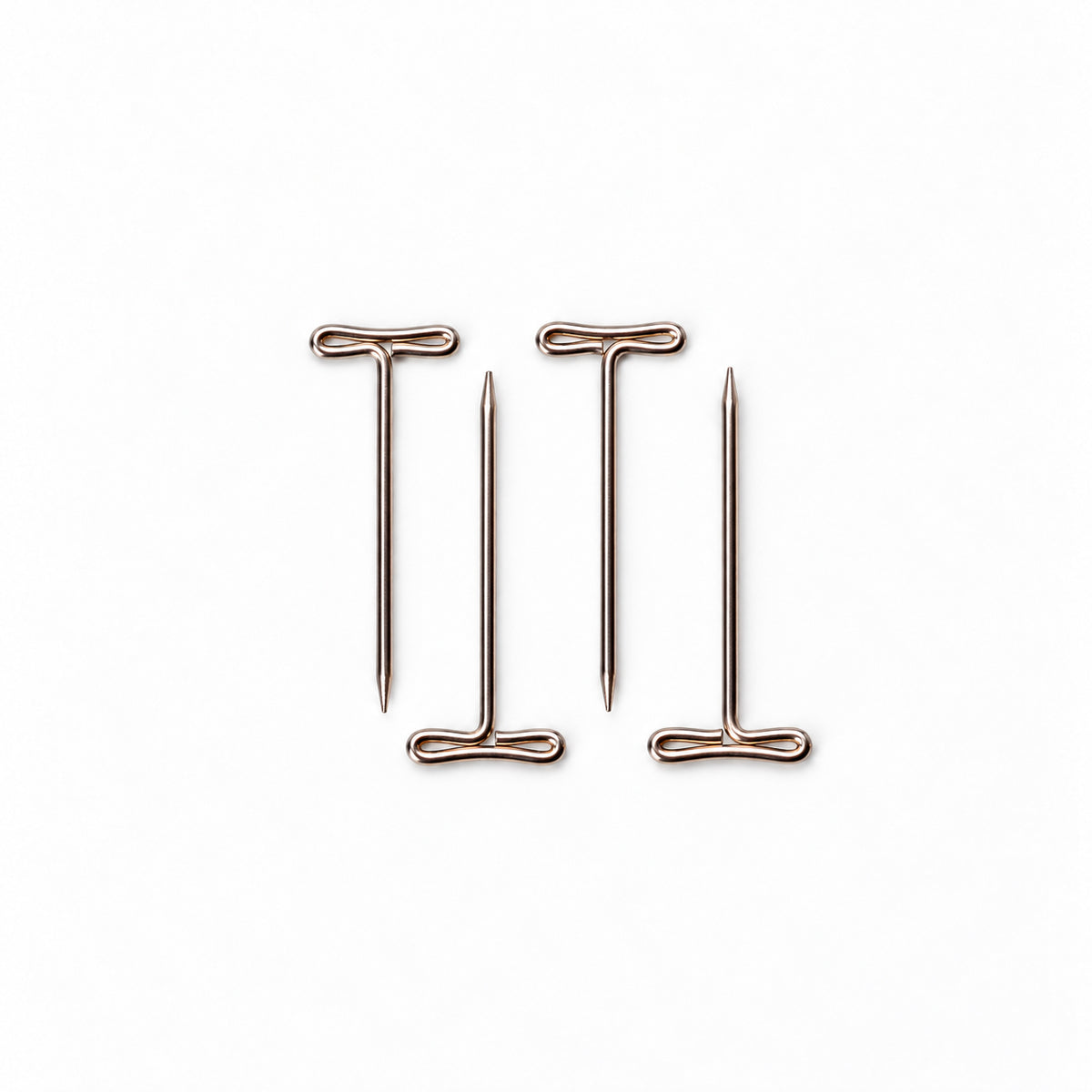 Four ChiaoGoo Mini [M] tightening keys on a white background, two with the handle at the top and two with the handle at the bottom. Each T-shaped wire key has a flat looped handle at one end and a thin tapered point at the other.
