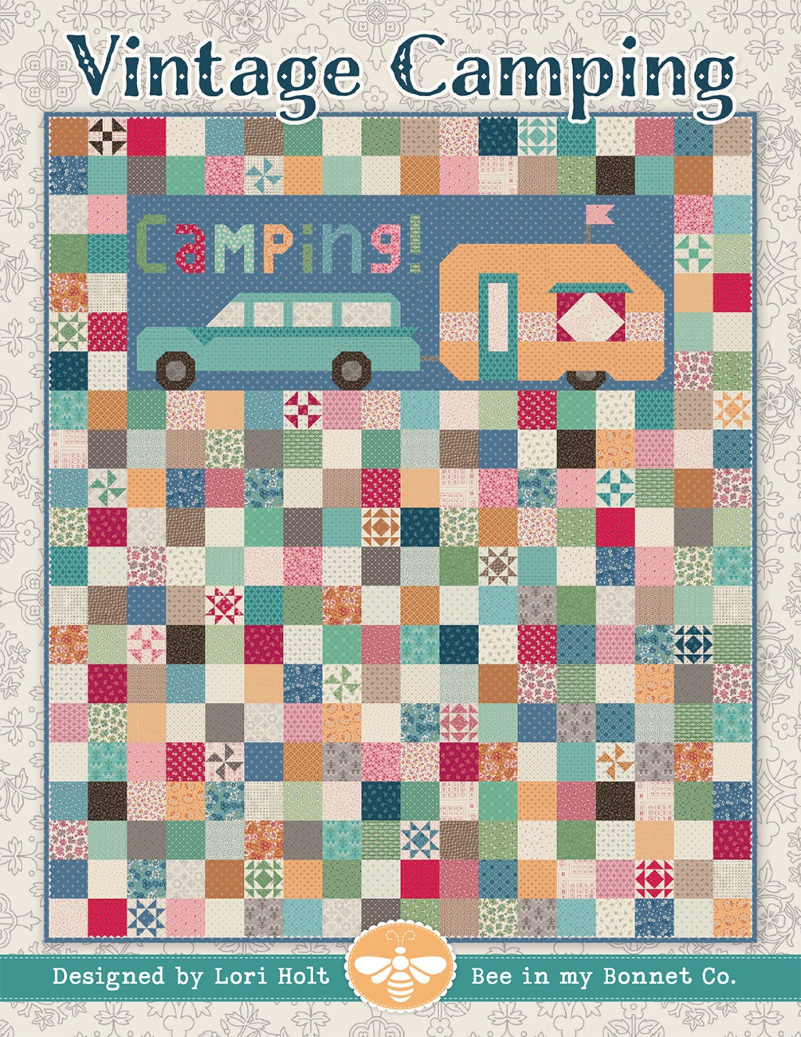 Vintage Camping quilt by Lori Holt for It's Sew Emma, a scrappy patchwork quilt with a pieced aqua station wagon towing an orange camper and the word Camping in pieced letters, surrounded by small scrappy squares and novelty blocks in vintage colors.