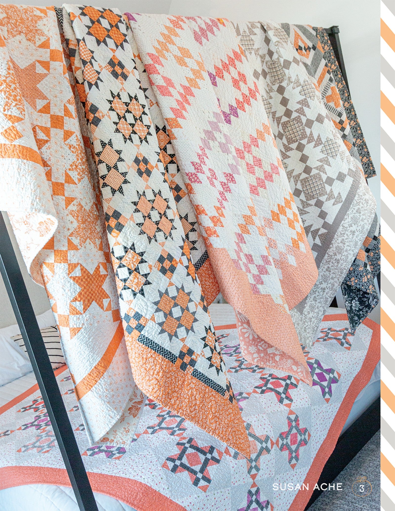A pieced Halloween quilt from Halloween Memories in orange and cream stars, draped outdoors among pumpkins.