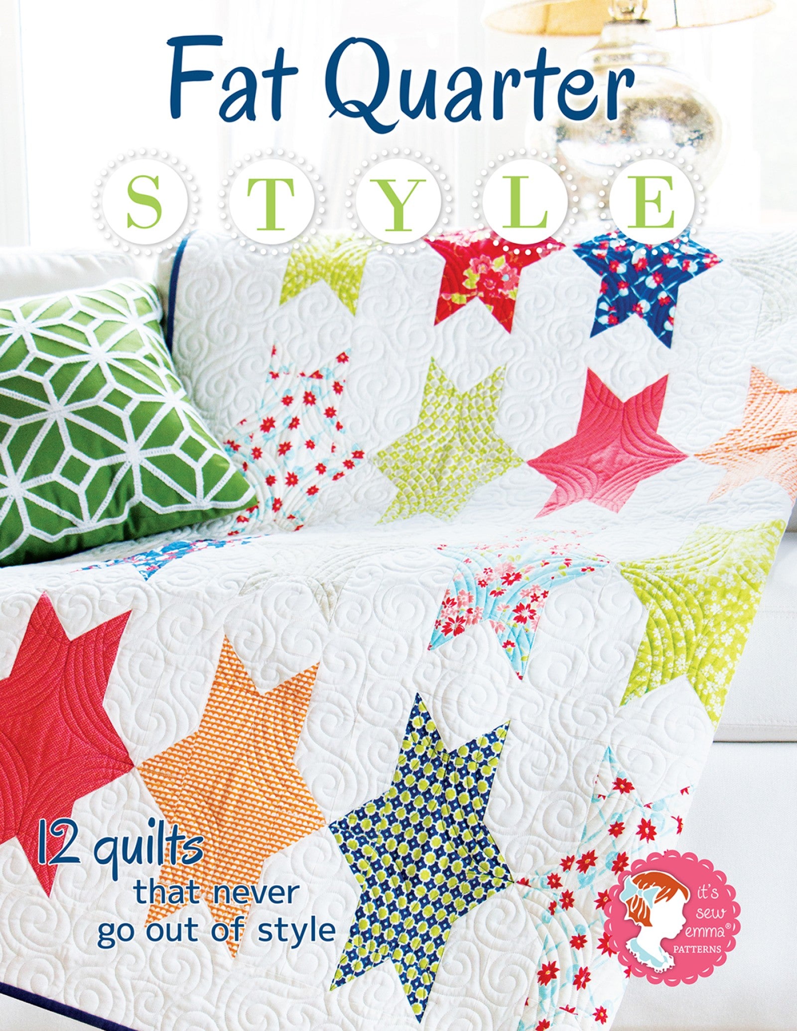 Front cover of Fat Quarter Style, a quilt pattern book from It's Sew Emma. A white star quilt in green, red, and blue fat quarter prints on a sofa, with the line 12 quilts that never go out of style.