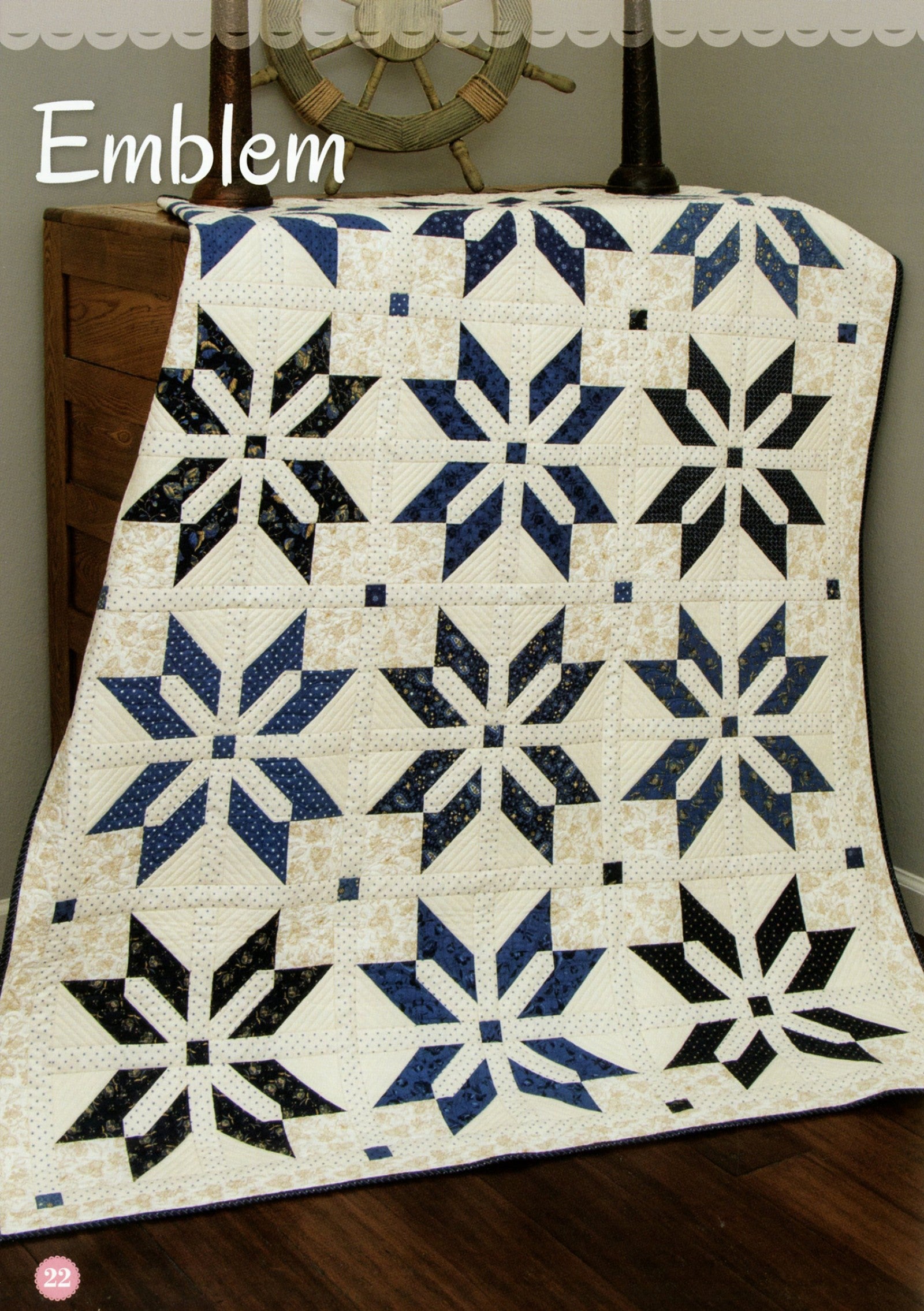 Emblem quilt from the Fat Quarter Style pattern book, eight-point star blocks in navy and black on a cream background.