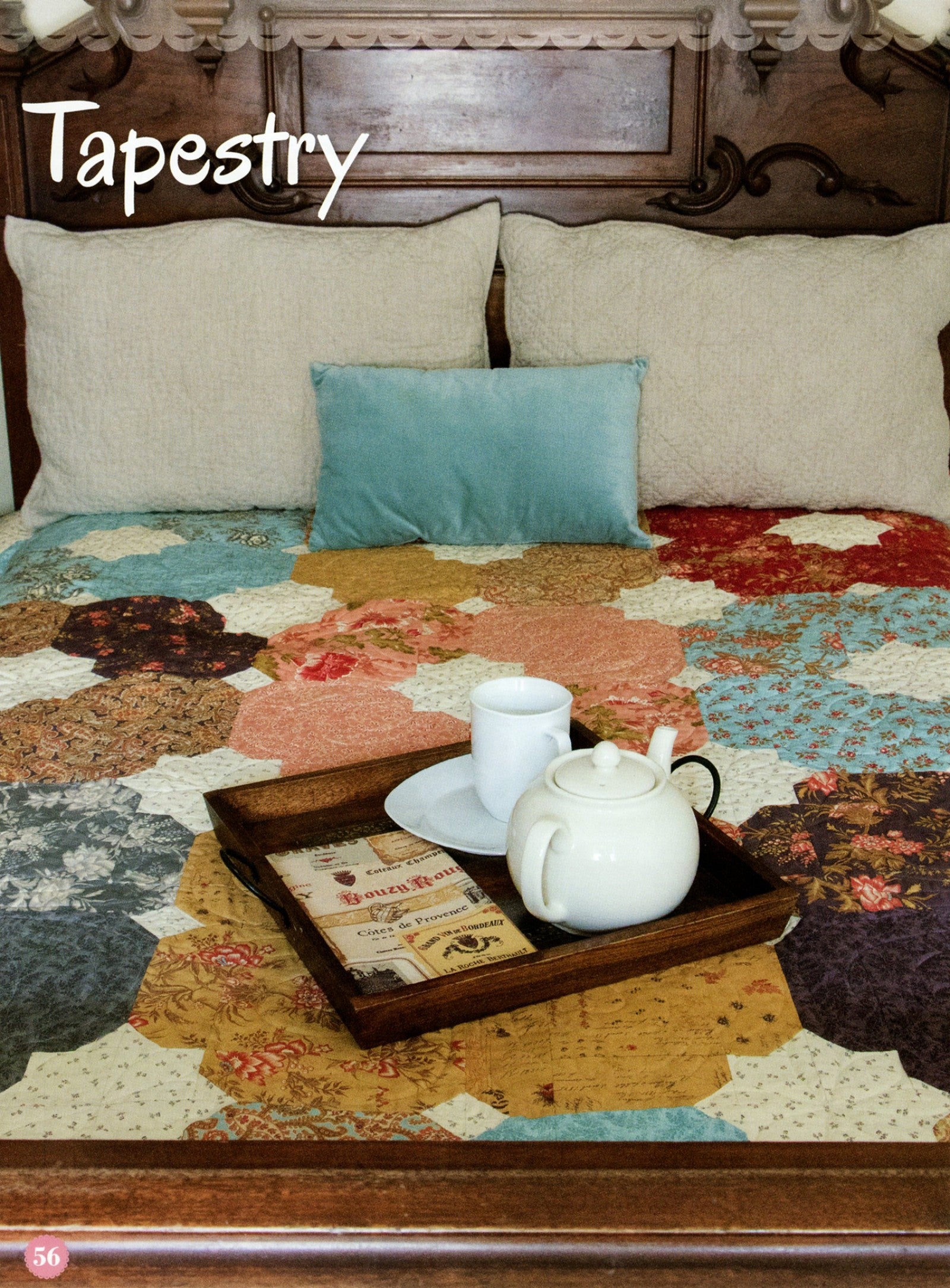 Tapestry quilt from the Fat Quarter Style pattern book, a hexagon flower garden in soft floral prints styled on a bed with a tea tray.