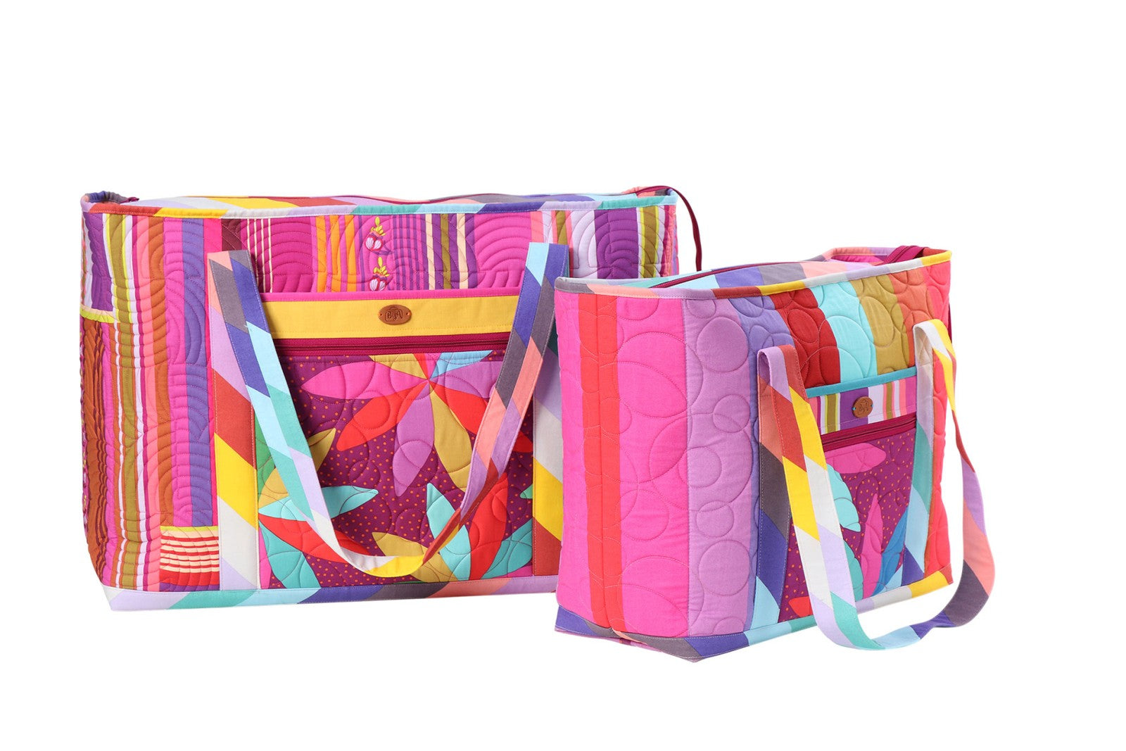 Two finished Two Big Totes in bright geometric and striped prints, showing the wide openings, front slip pockets, and over-the-shoulder handles.