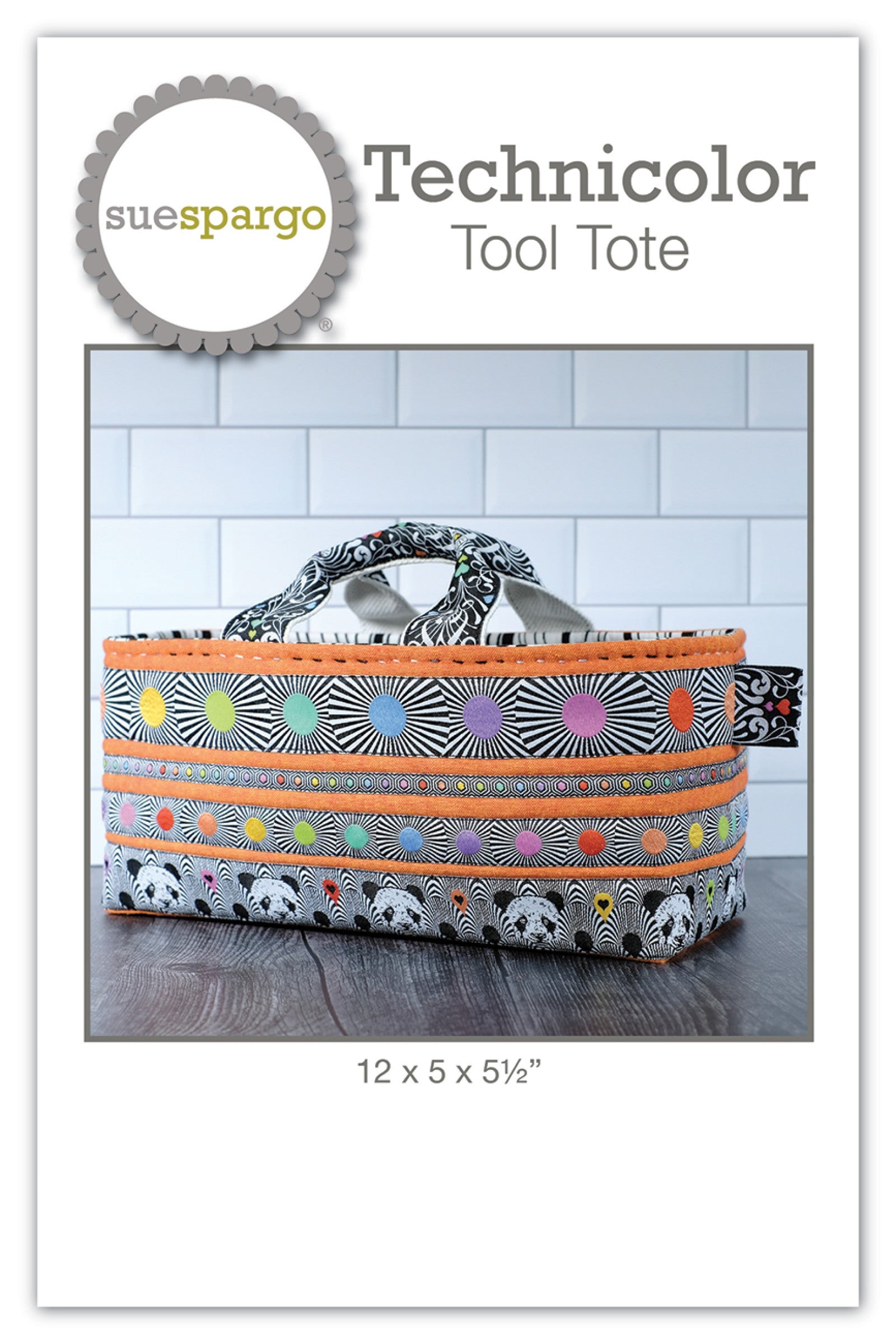 Technicolor Tool Tote sewing pattern by Sue Spargo of Folk Art Quilts. Front cover shows the finished padded tote in black-and-white print banded with bright printed ribbons in dots, stripes, rainbow hexies, and pandas, with an orange accent, hand-stitched top edge, and fabric handles. Finished size 12 by 5 by 5-1/2 inches.