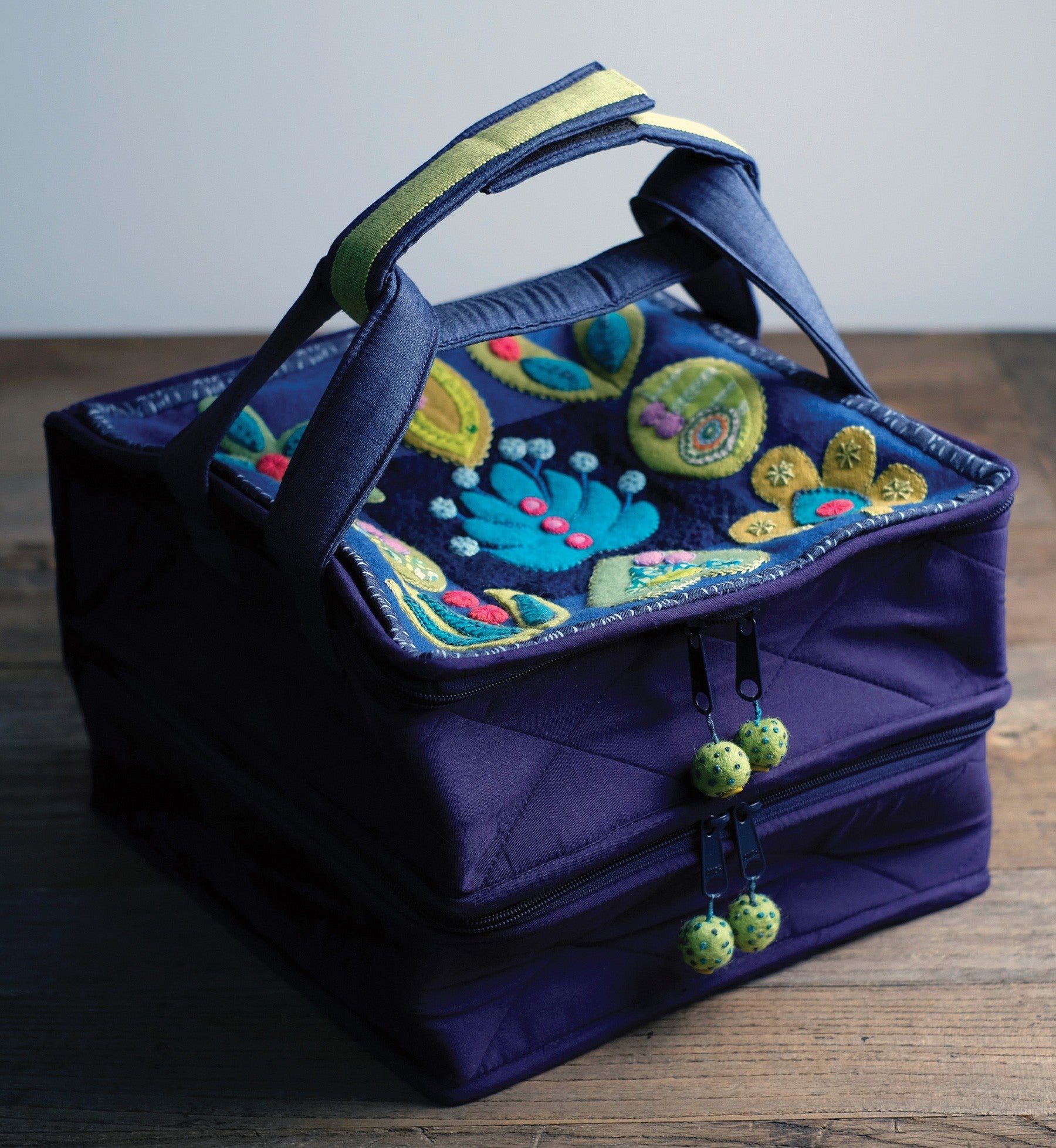 The Forest for the Trees Workbox, a bonus project, a deep blue fabric project box with a leaf appliqued on the front and carry handles.