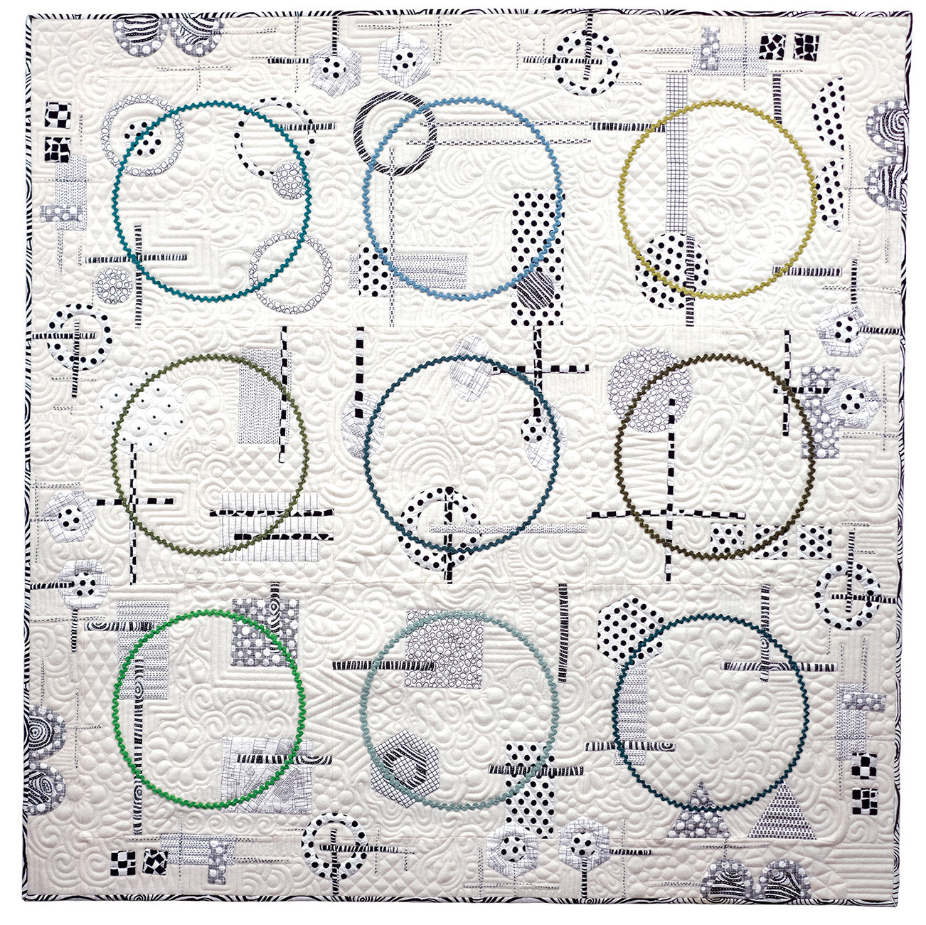 The Of a Feather Geometric Throw, a bonus project, a cream throw covered in embroidered circles and hoop motifs in muted thread.