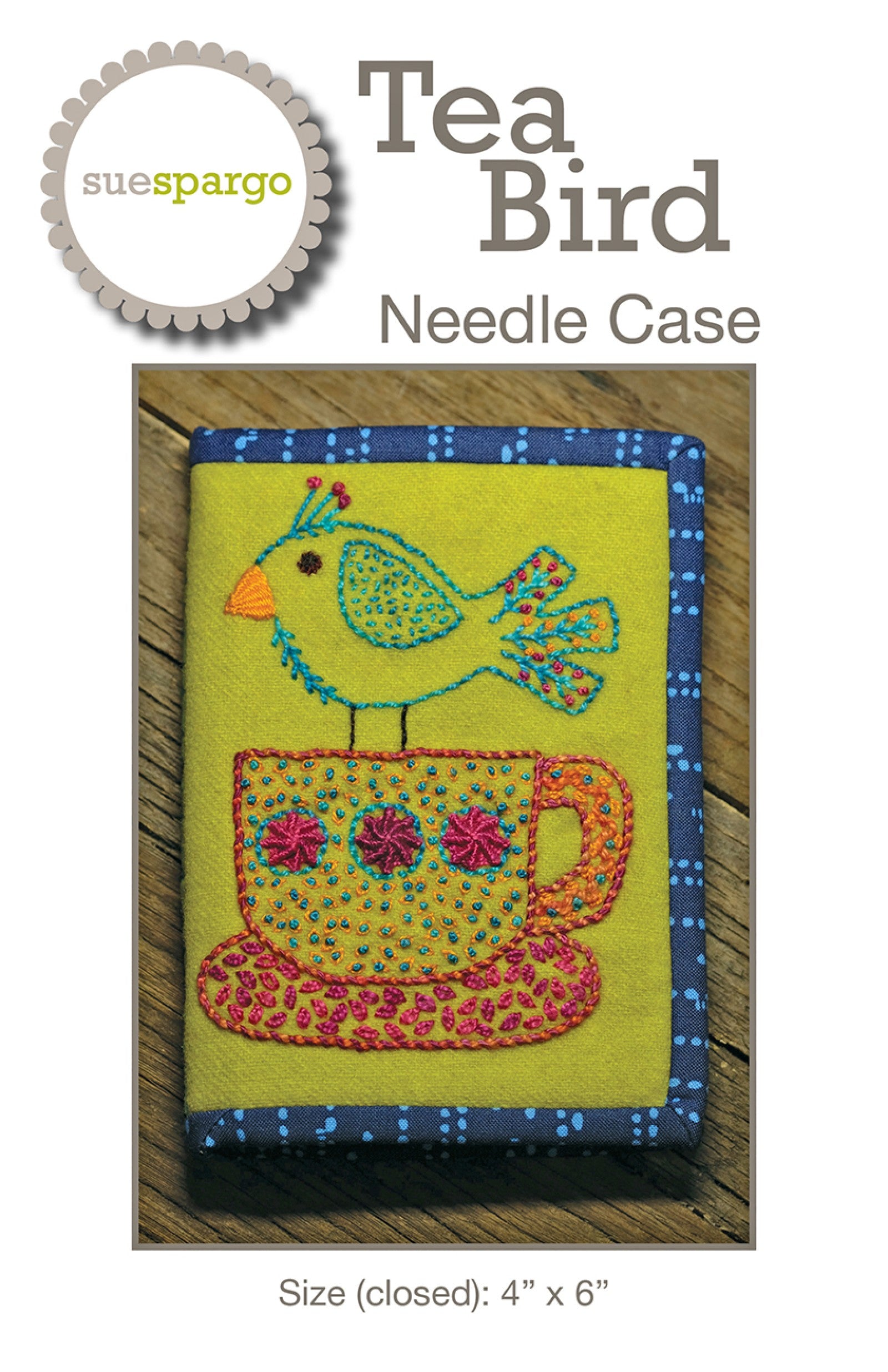 Tea Bird Needle Case sewing pattern by Sue Spargo of Folk Art Quilts. Front cover shows the finished needle case in lime-green wool bound in blue polka-dot cotton, with an entirely hand-embroidered design: a whimsical bird perched on a teacup, worked in seed stitches, French knots, and woven roses. Size 4 by 6 inches closed shown.
