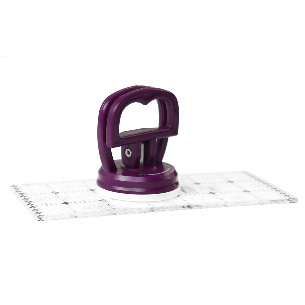 The Amazing Little Gripper attached to a clear acrylic ruler on a white background.